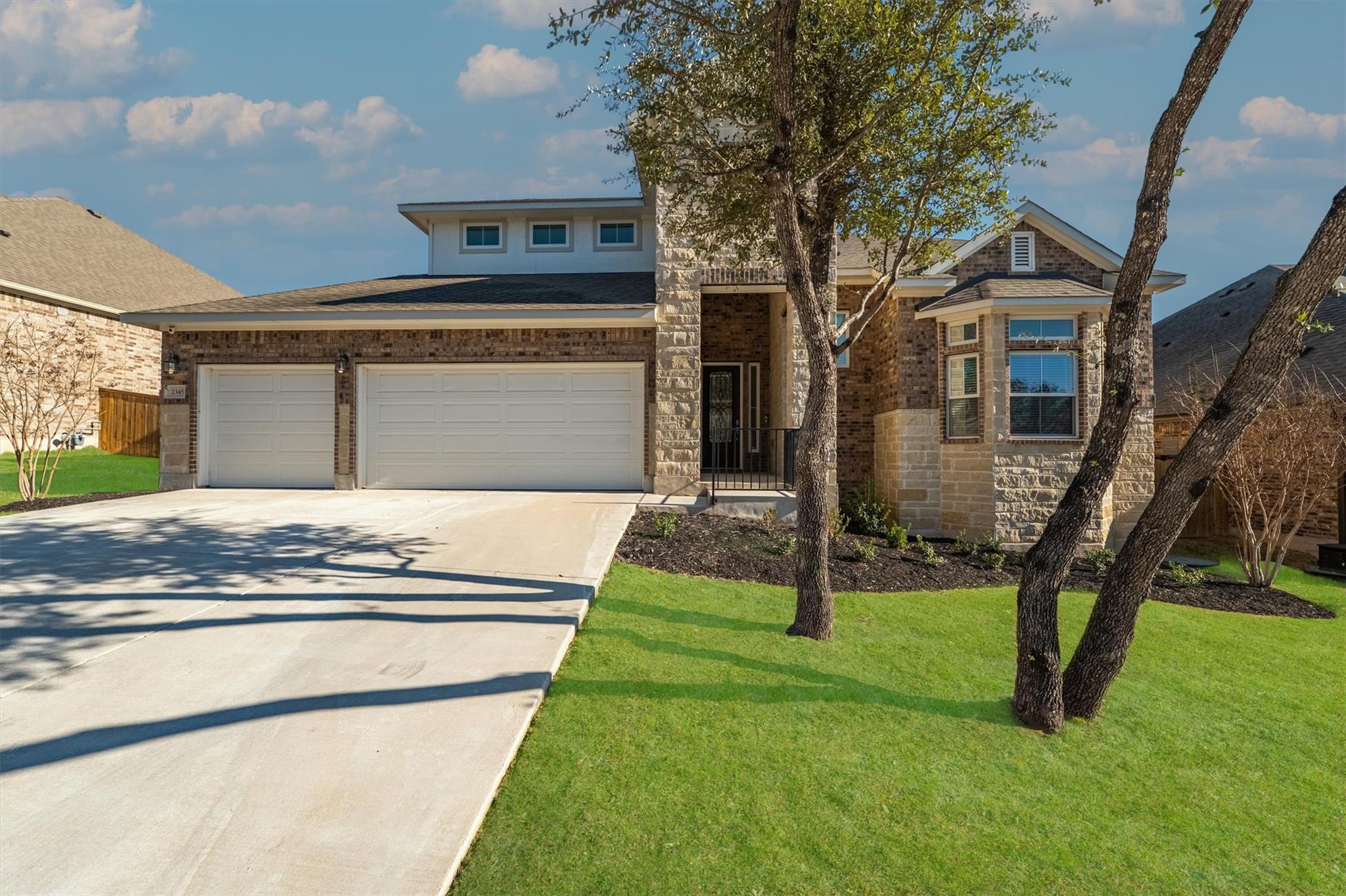 An inviting stone and brick facade sits nestled b