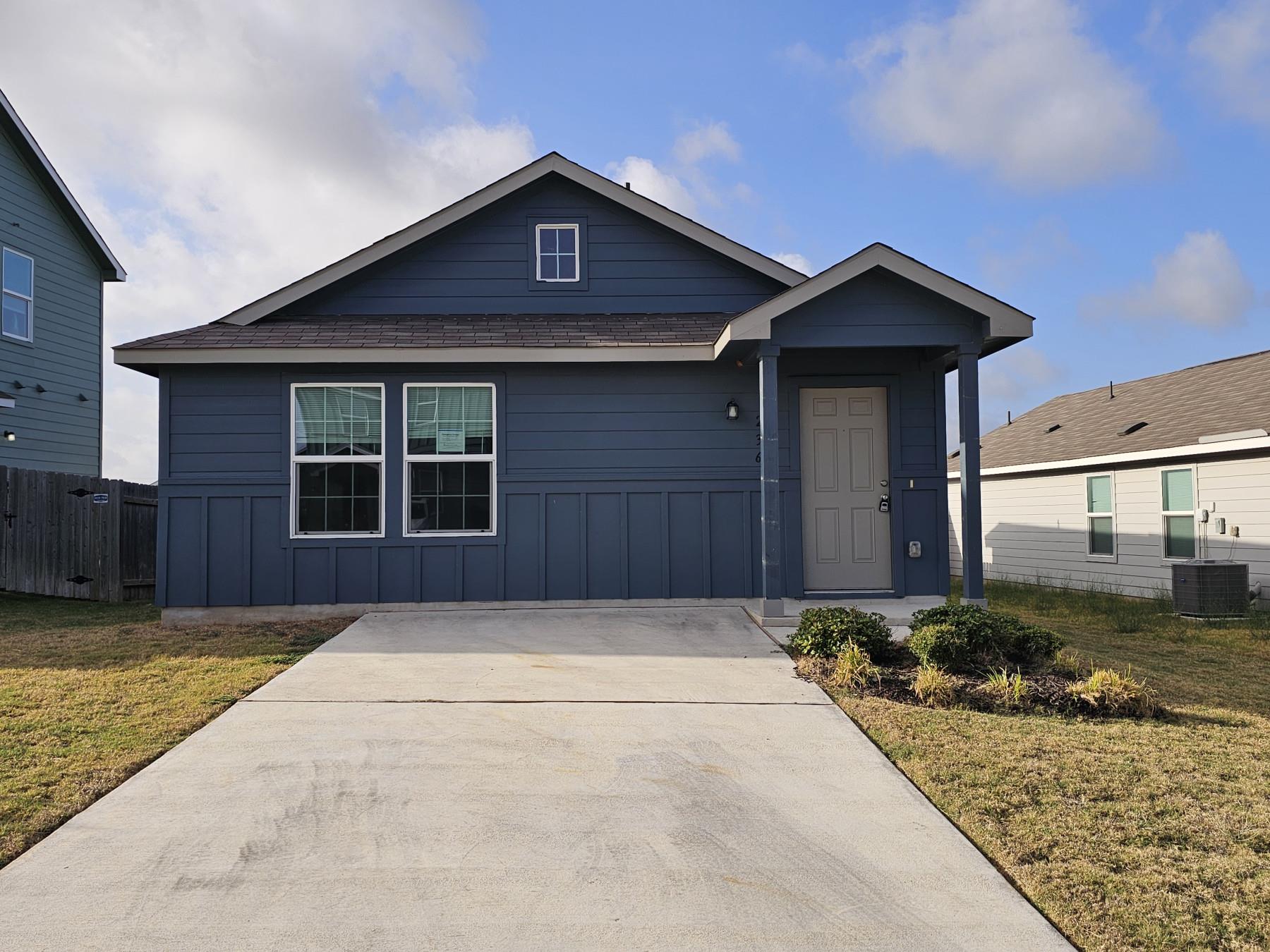 A concrete driveway leads to the covered front en