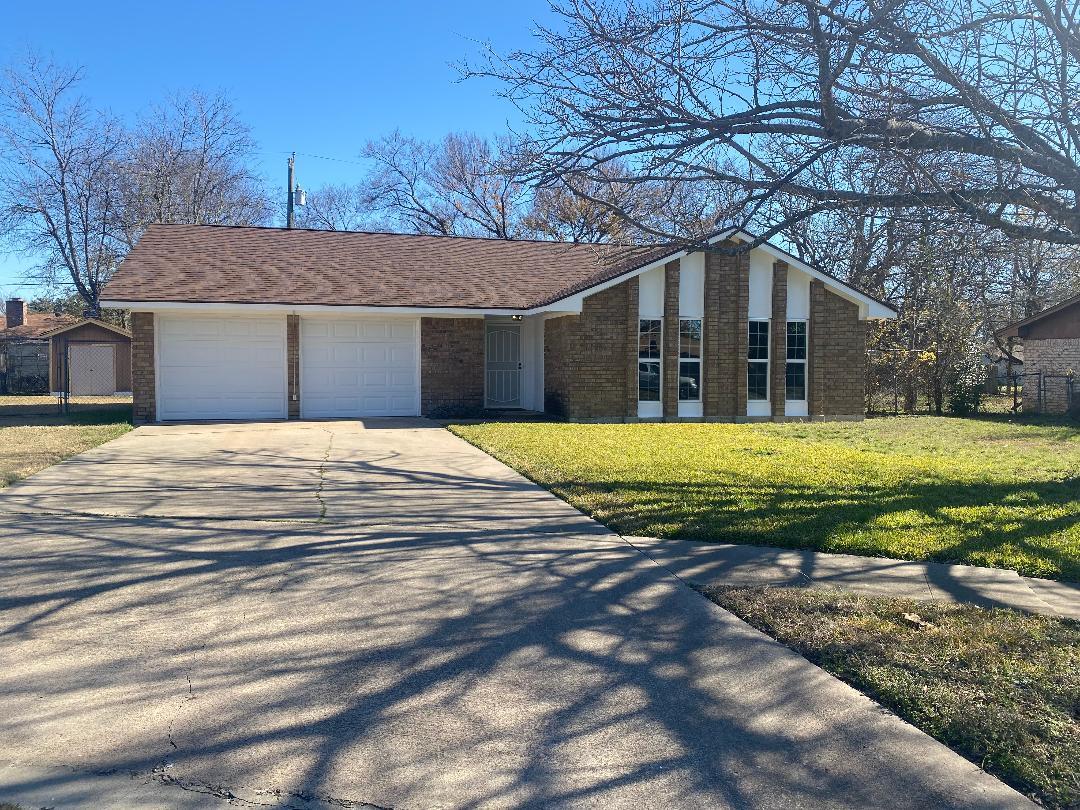 A classic brick exterior and long driveway frame 