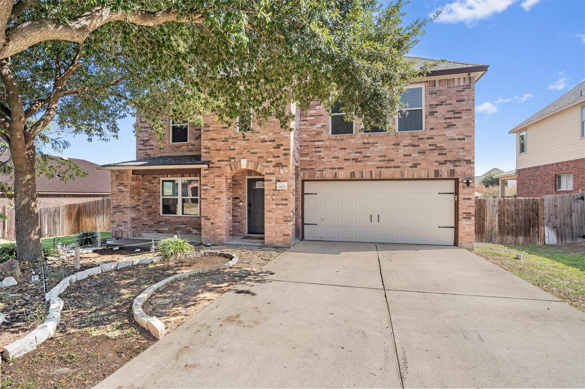 An inviting brick facade and wide driveway establ