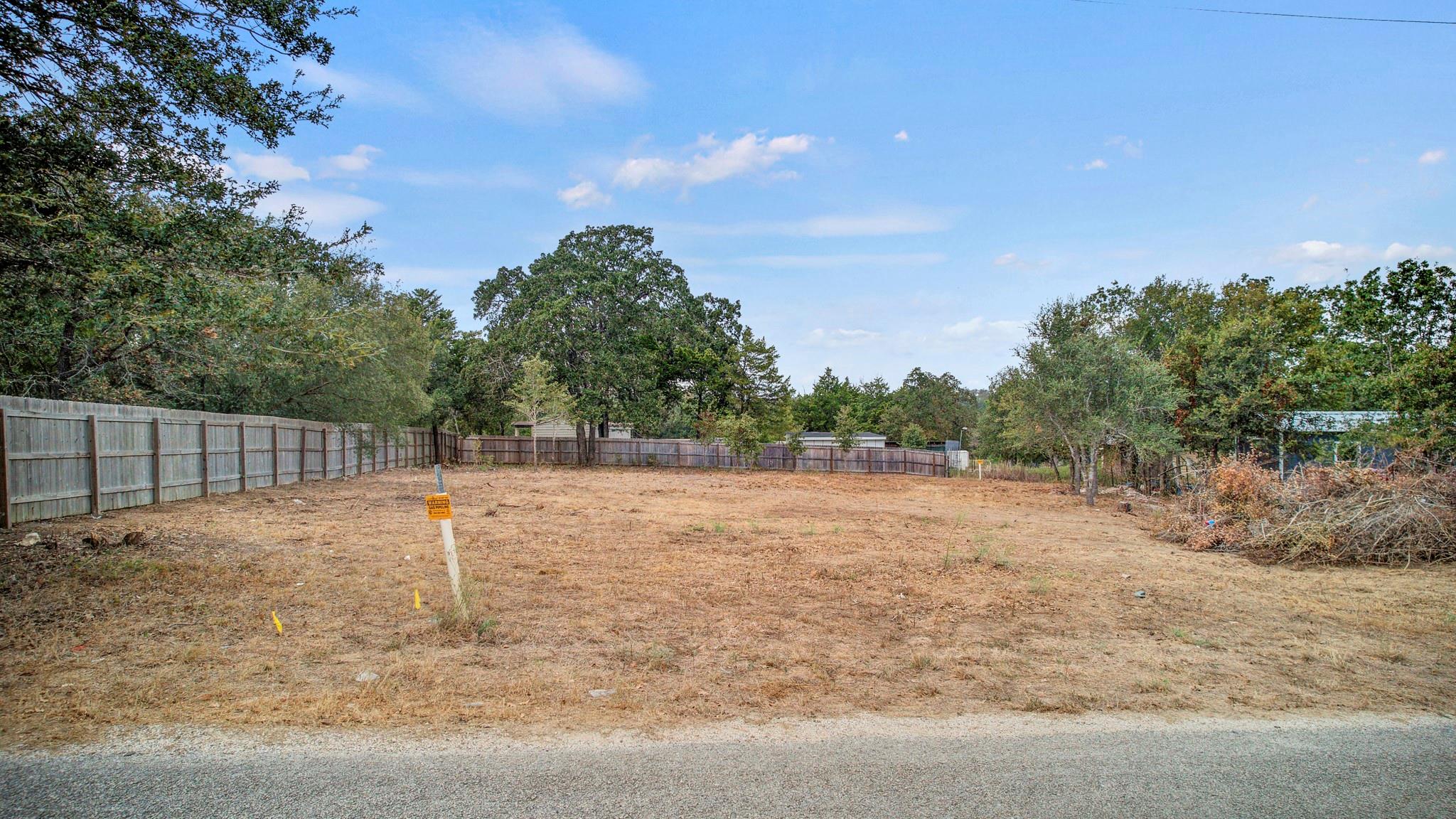 Mature trees frame a level, cleared building site