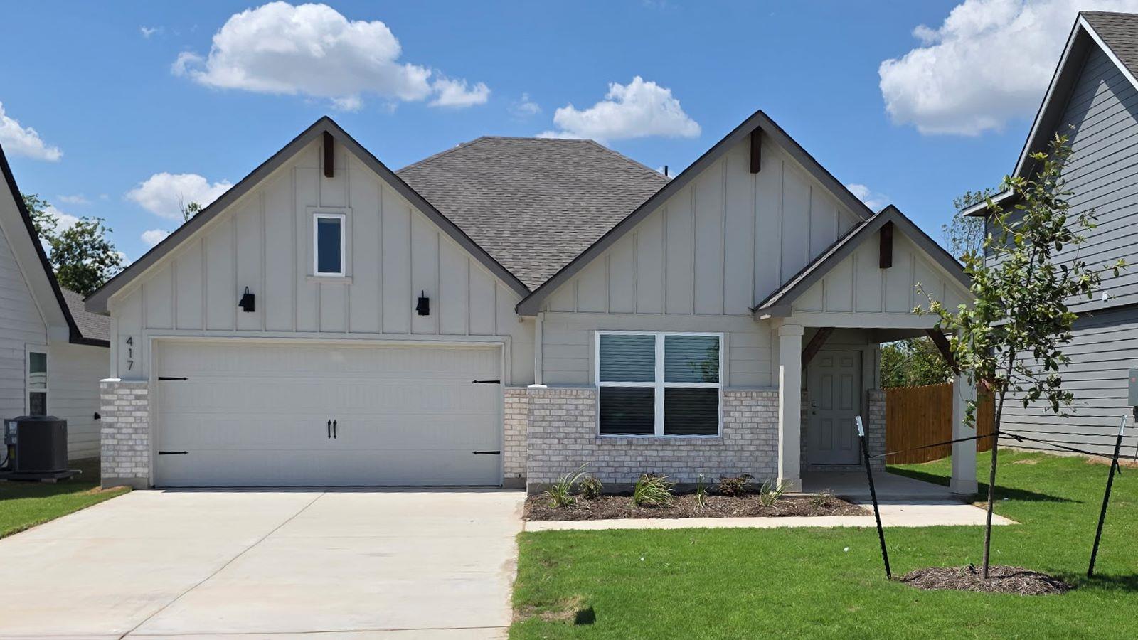 Gabled rooflines and a concrete driveway define t