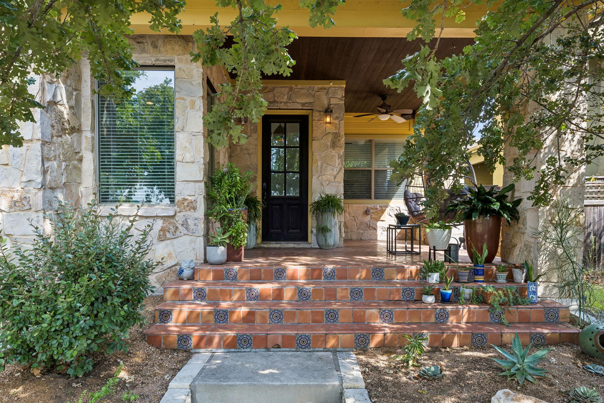 Decorative tiled steps lead to a welcoming stone 