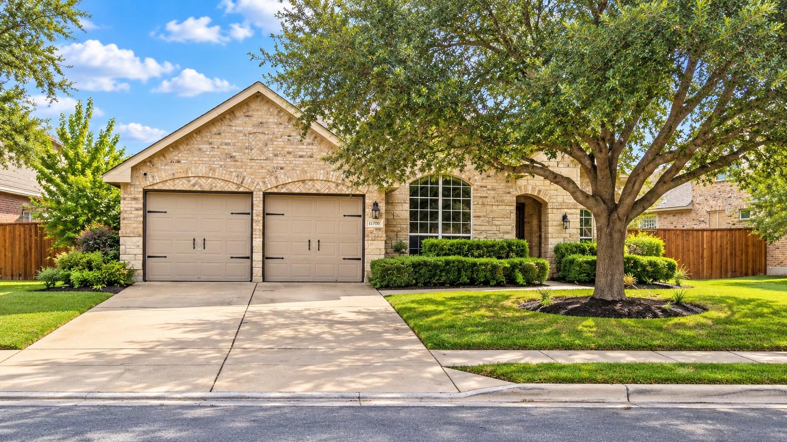 Mature trees shade the classic stone facade and d