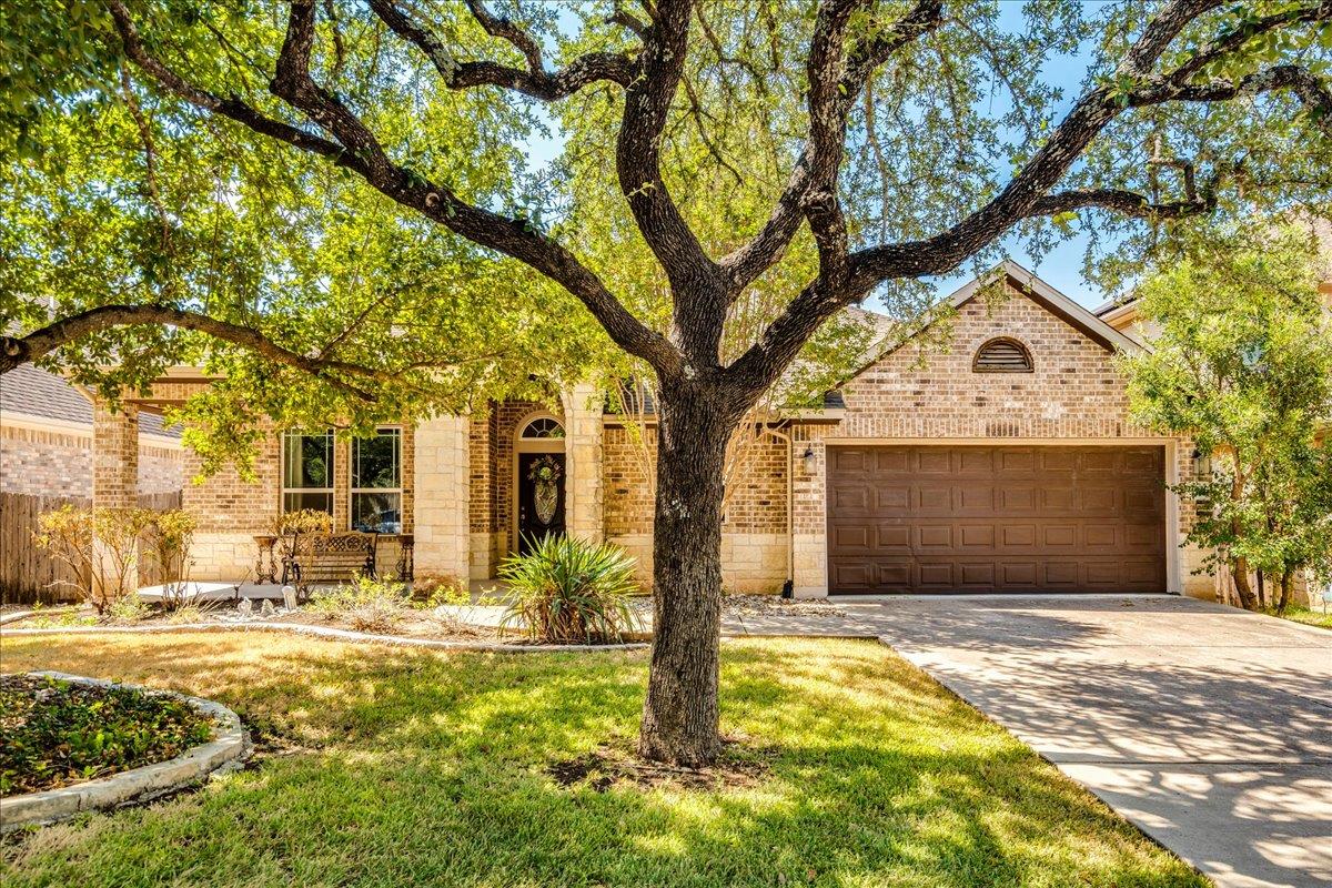 Mature oak trees frame a classic brick exterior c