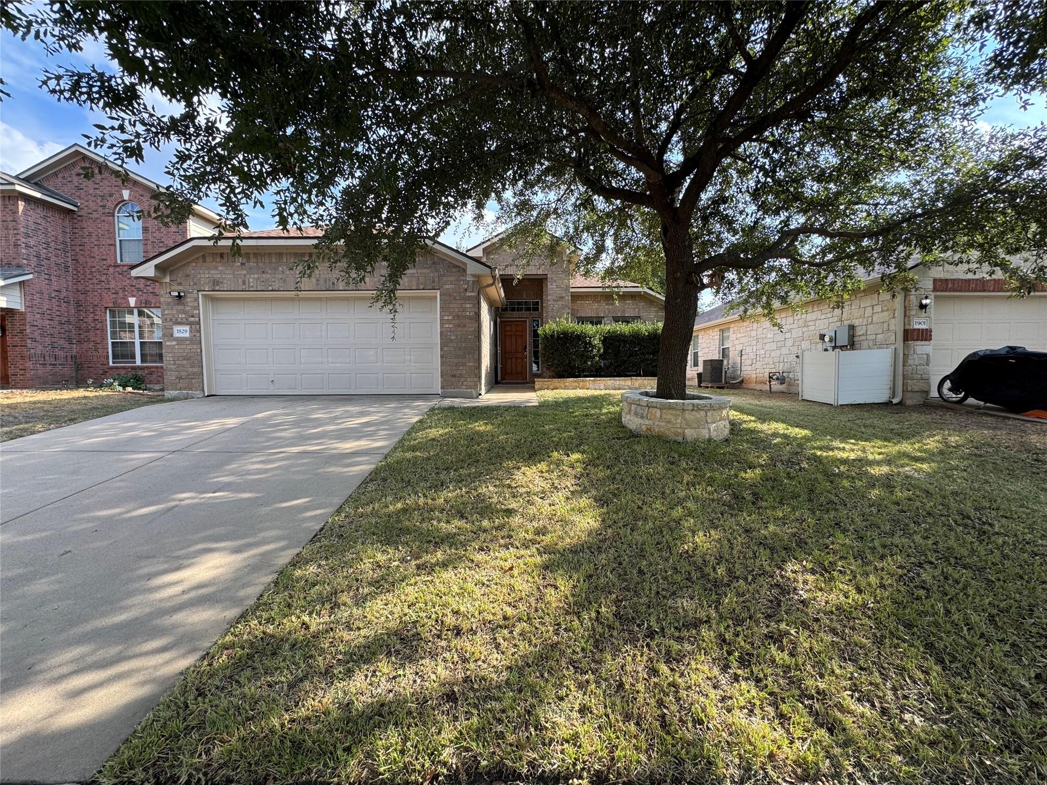 Mature shade trees and brick masonry define the e