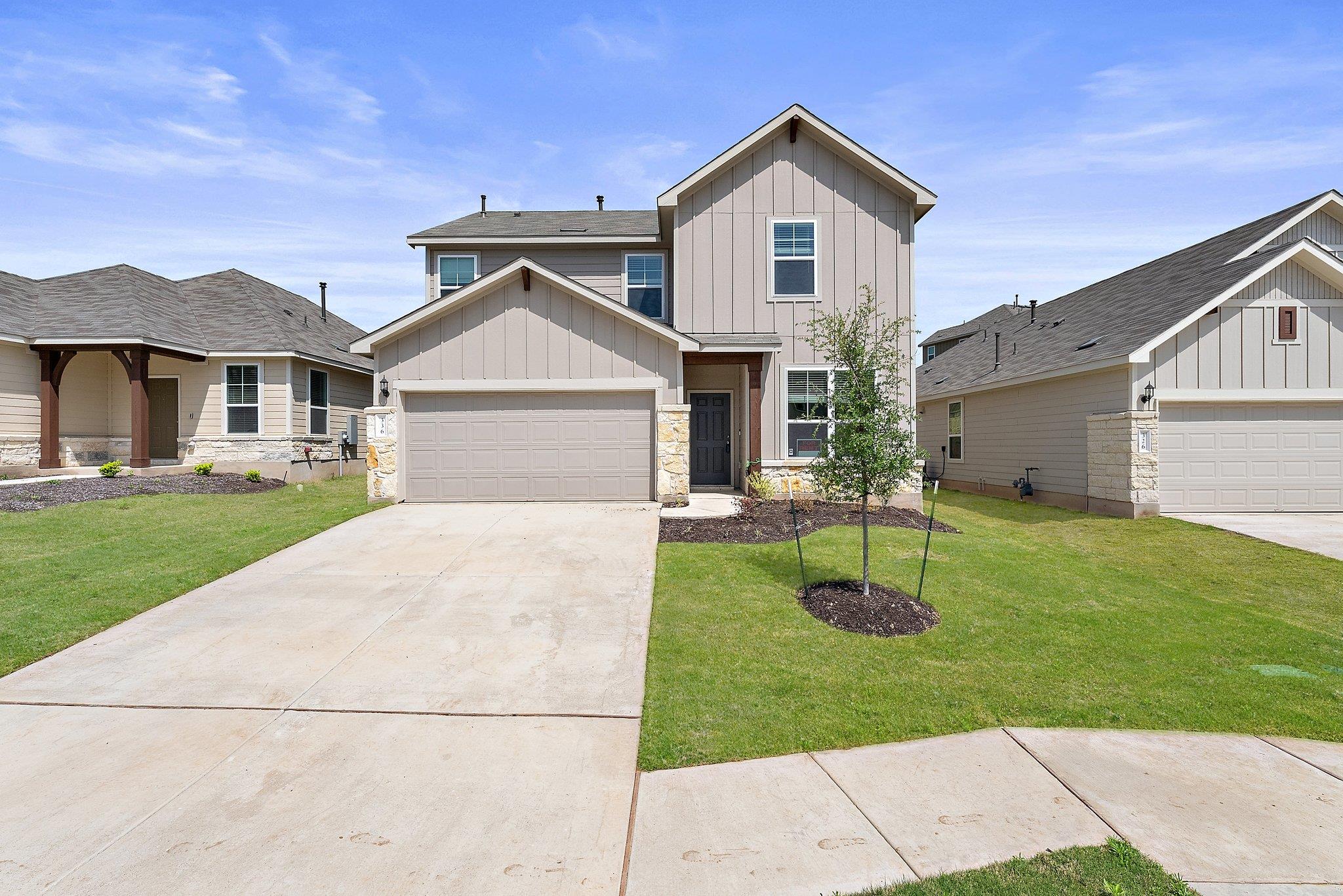 A concrete driveway leads to this modern two-stor