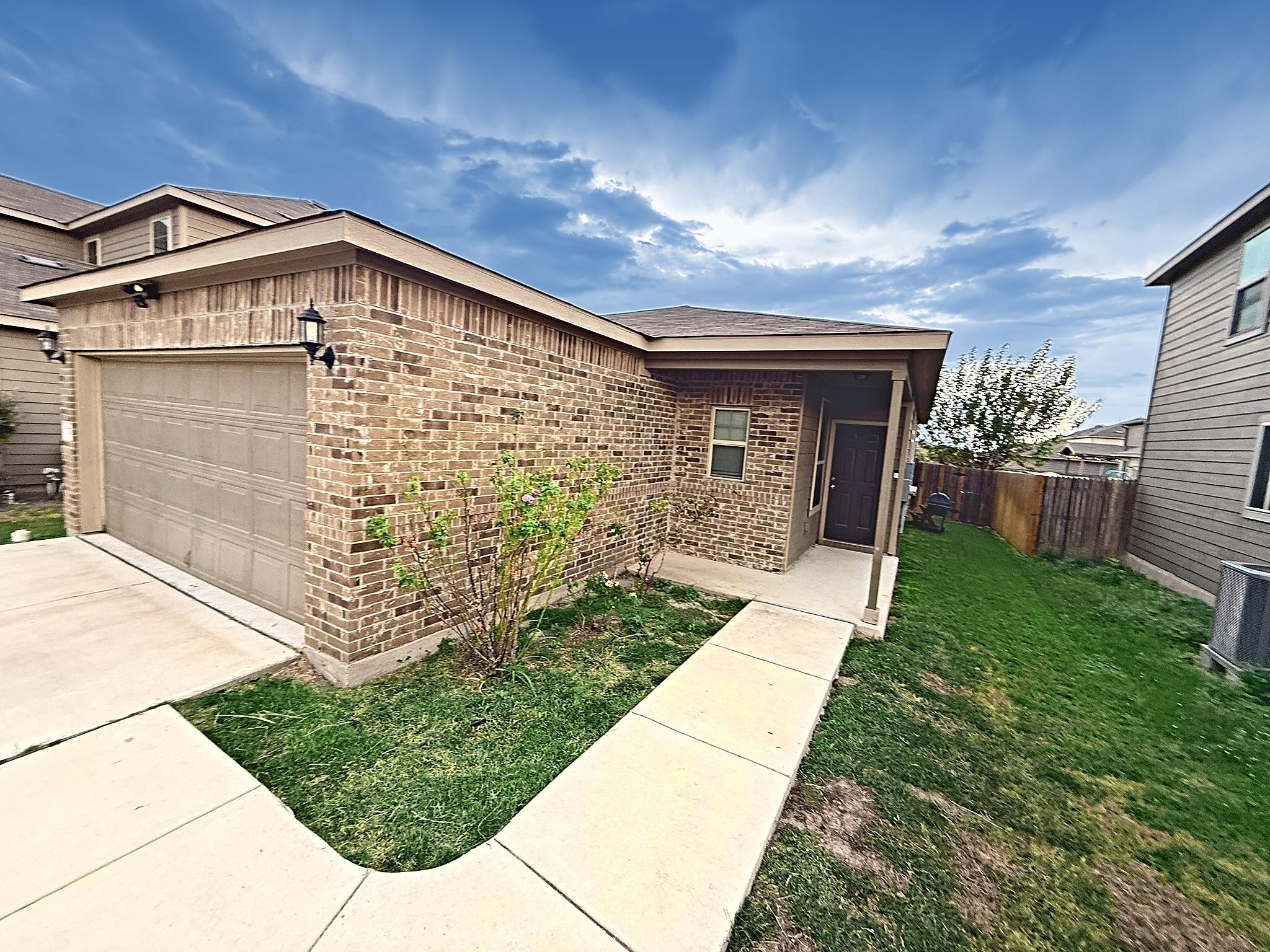A concrete walkway leads past a brick exterior to