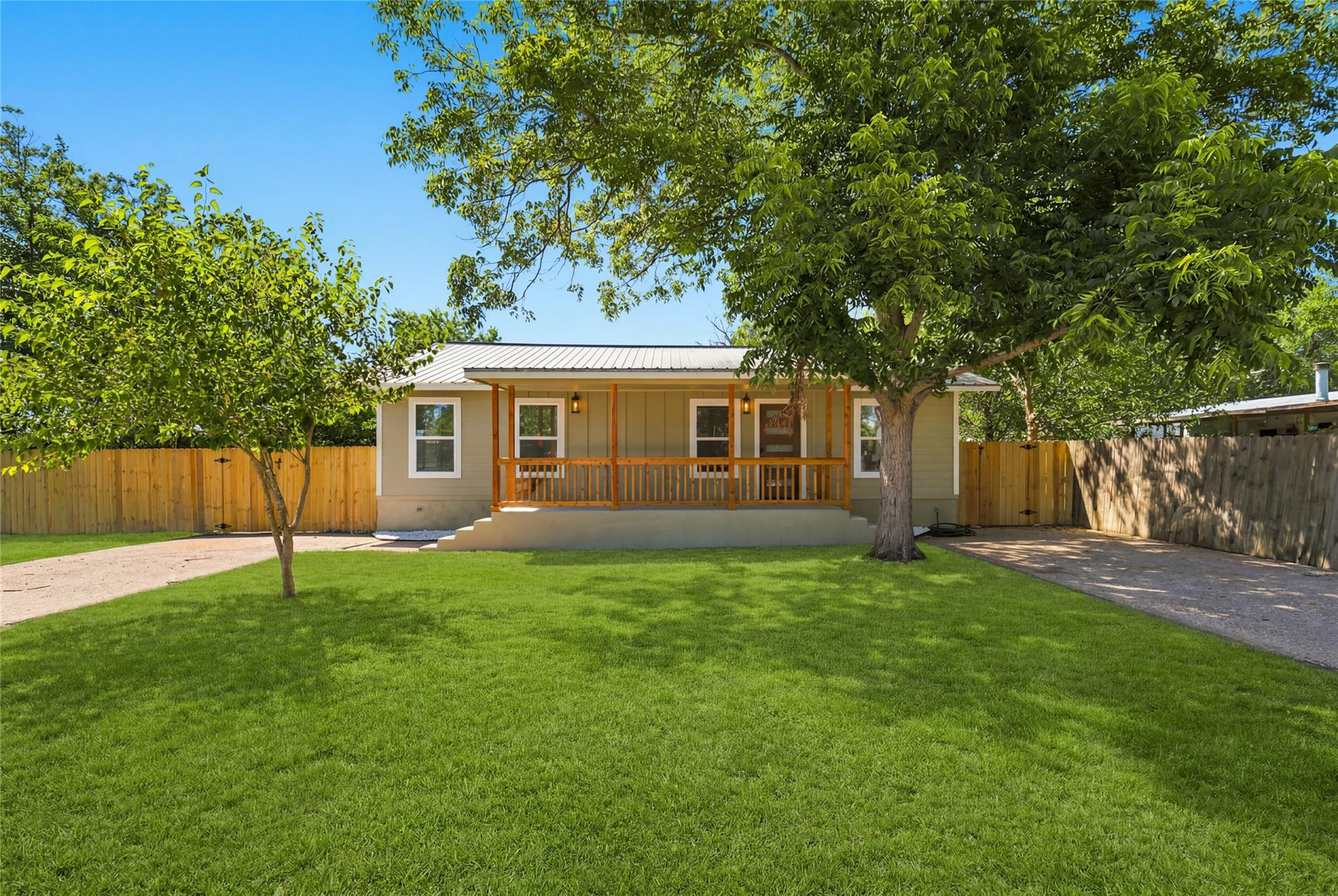 Mature trees shade a welcoming front porch set ag