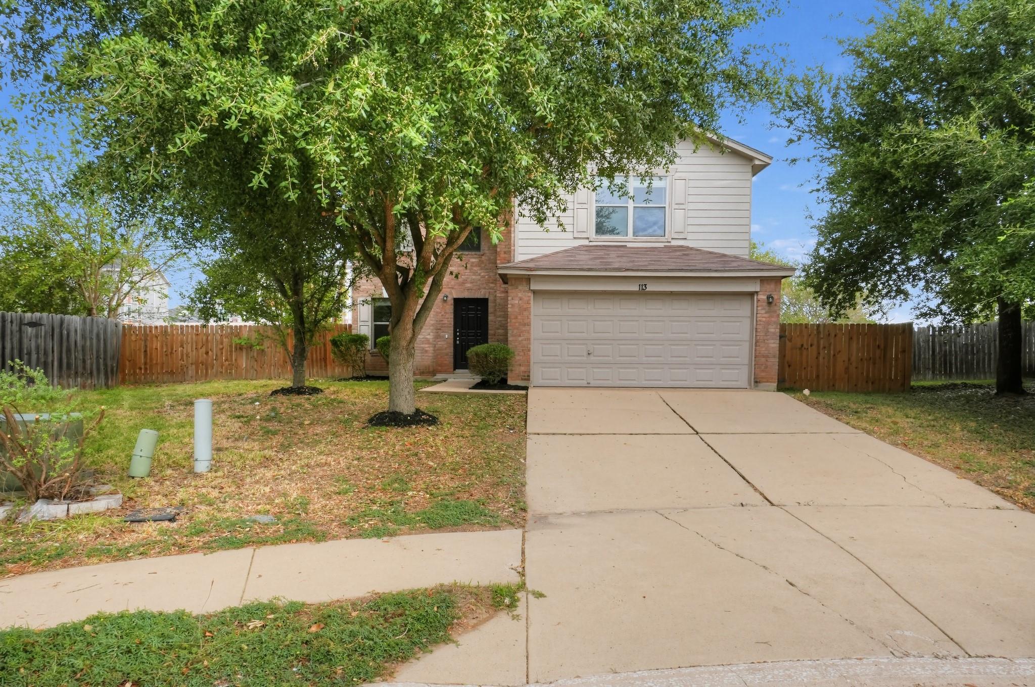 Mature trees shade the front yard and concrete dr