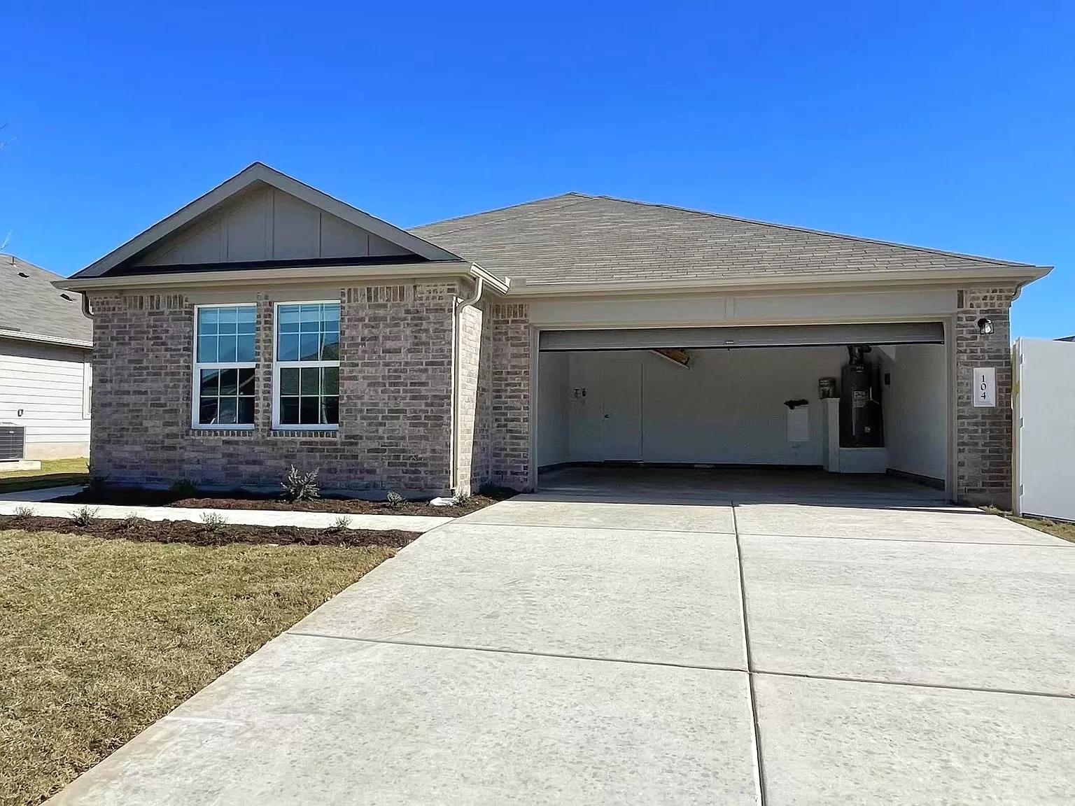 A wide concrete driveway leads to the spacious ga