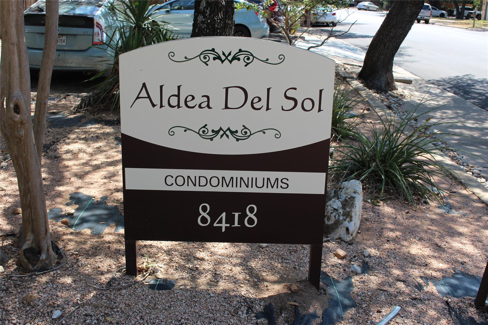 A prominent neighborhood sign welcomes residents 