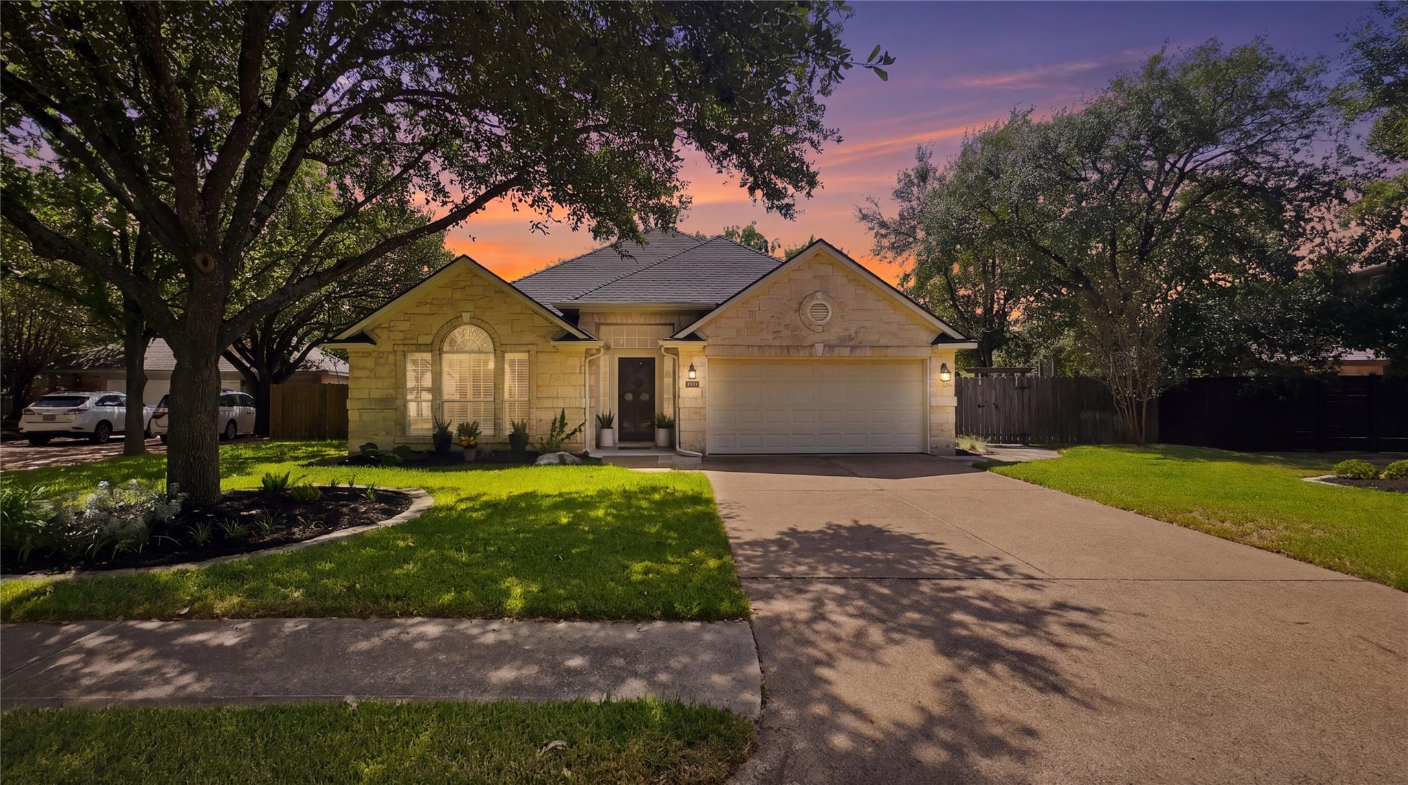Mature trees shade a classic stone exterior with 
