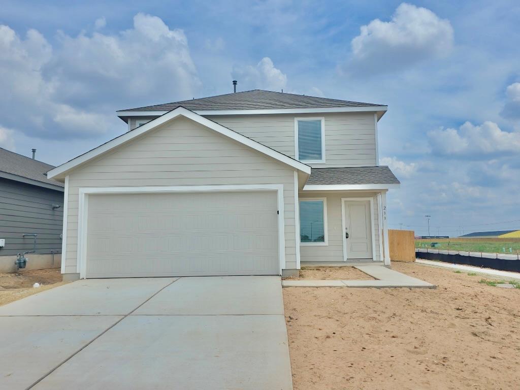 A concrete driveway leads to a modern two-story h