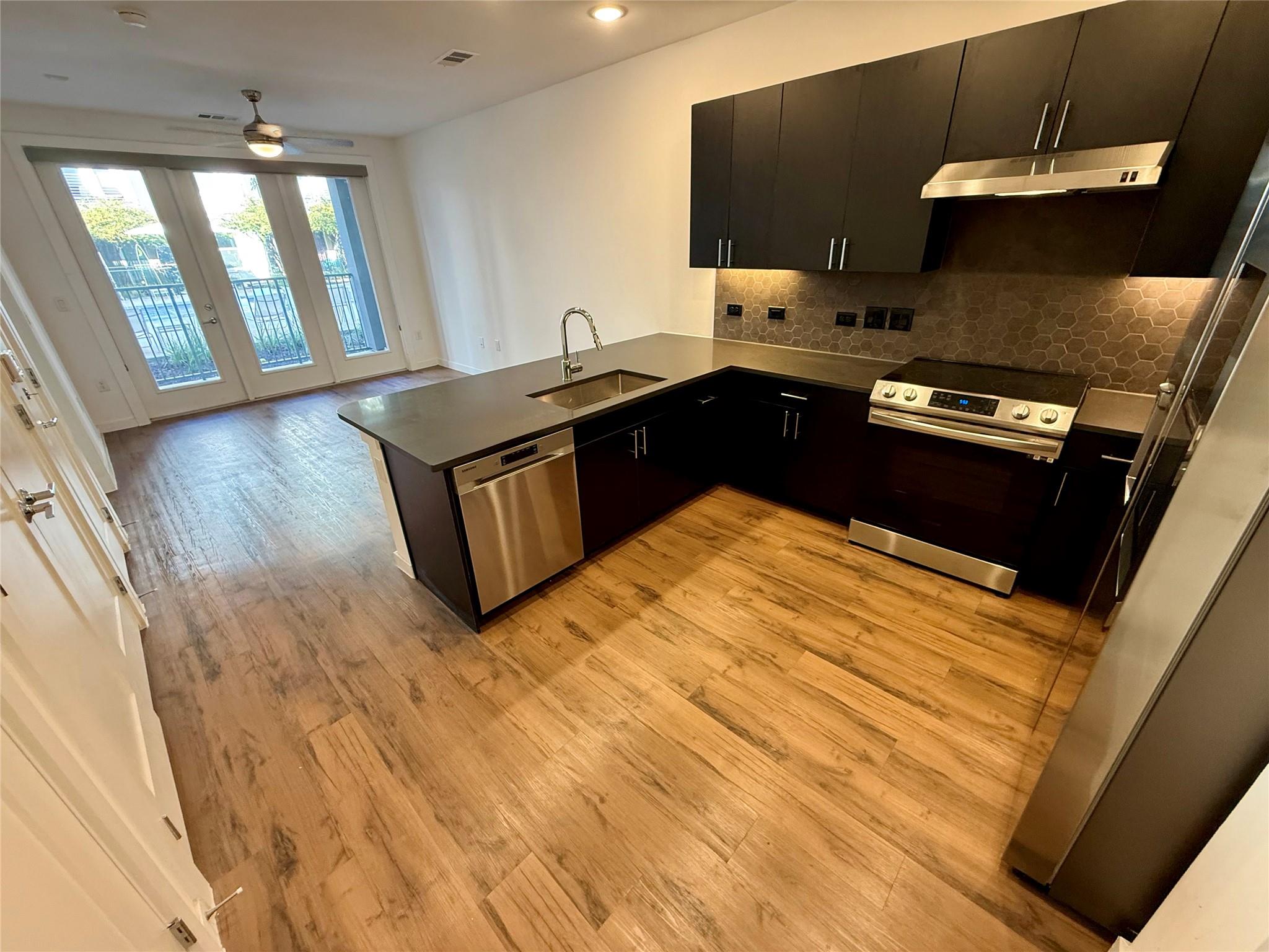 Gleaming wood floors anchor a modern kitchen unde