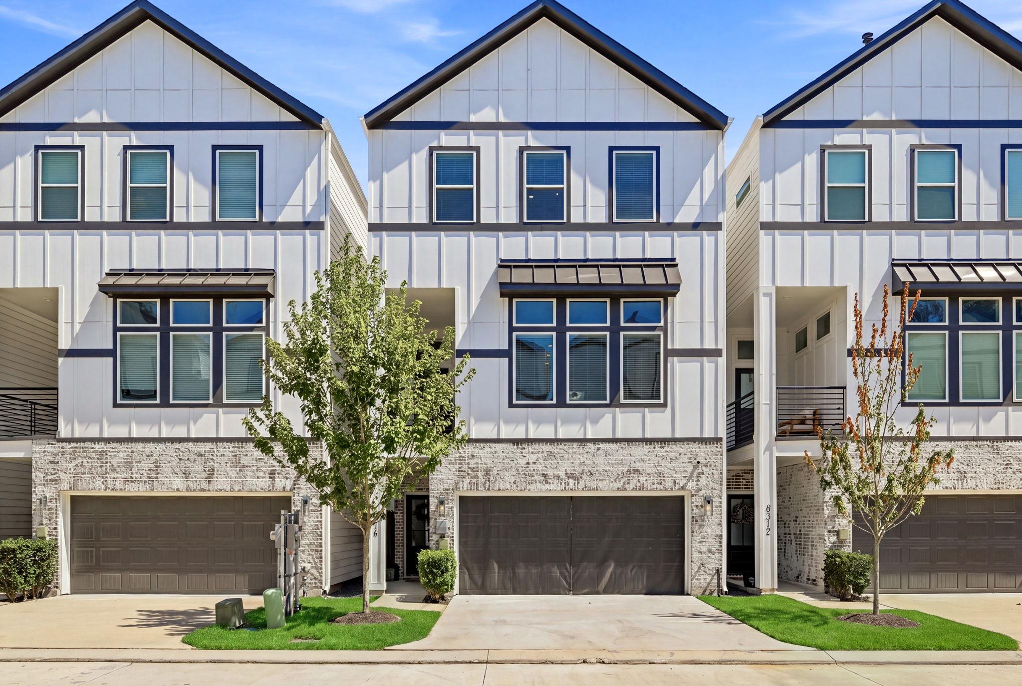 Striking vertical siding and brick accents define