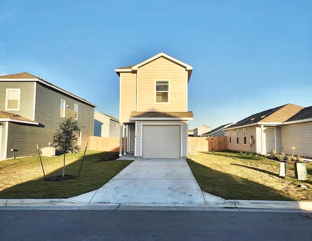 A concrete driveway leads to a single-car garage 