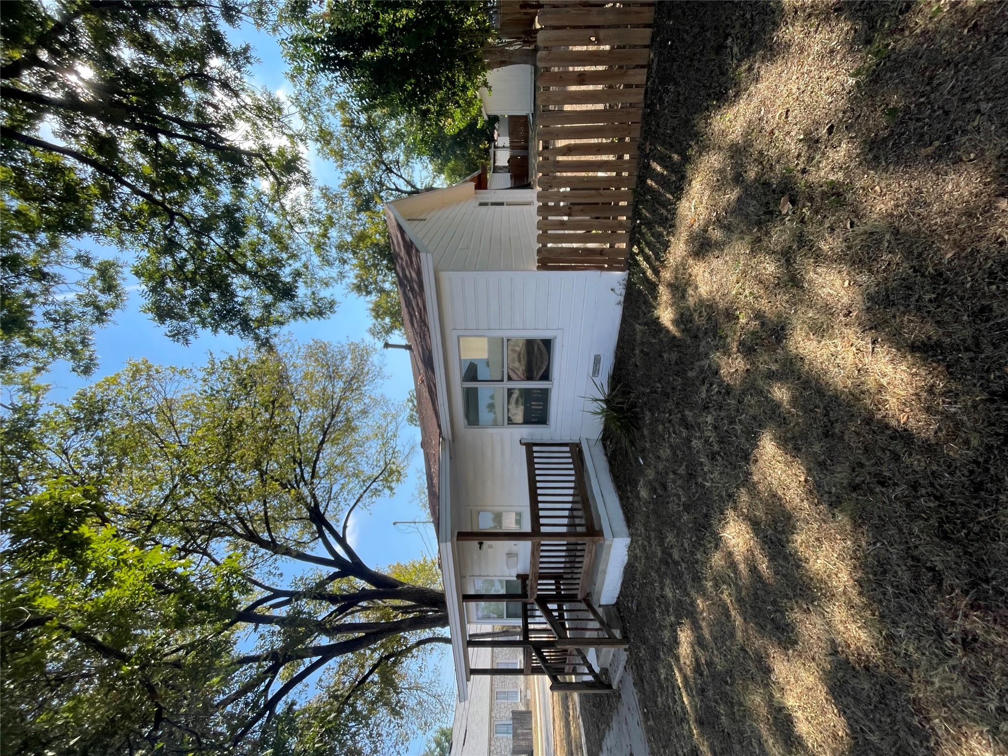 Mature trees shade a welcoming front porch and a 