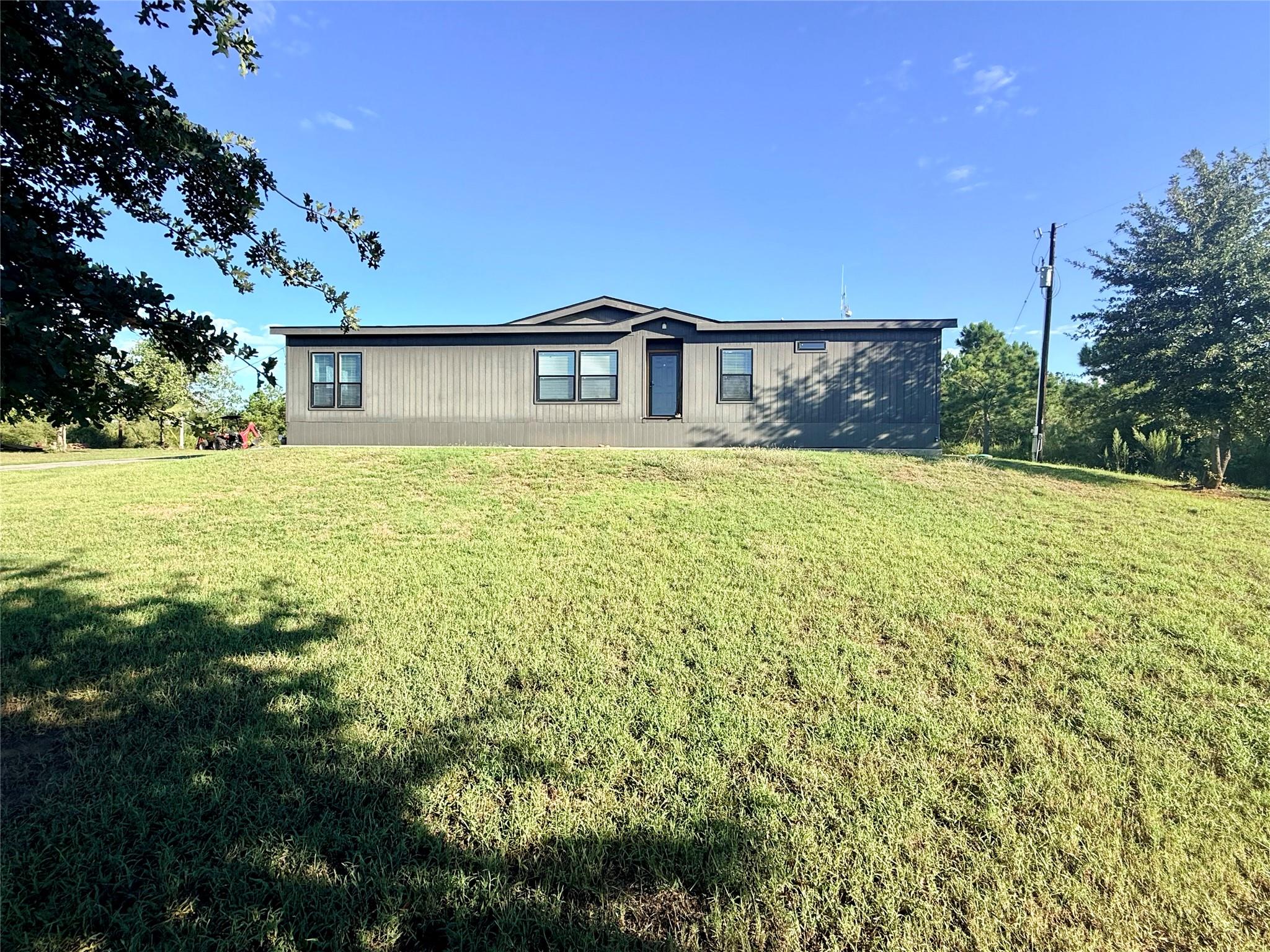 A modern exterior set against a spacious grassy l