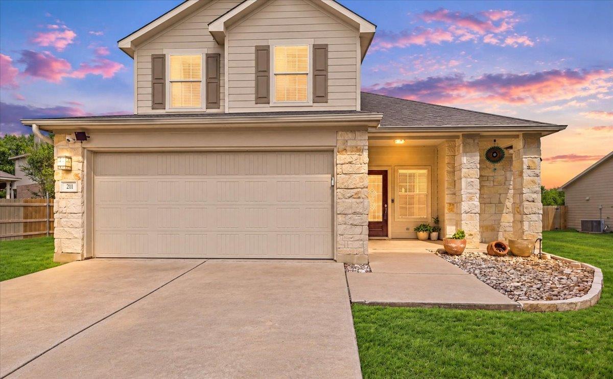 Textured stone pillars and classic siding define 