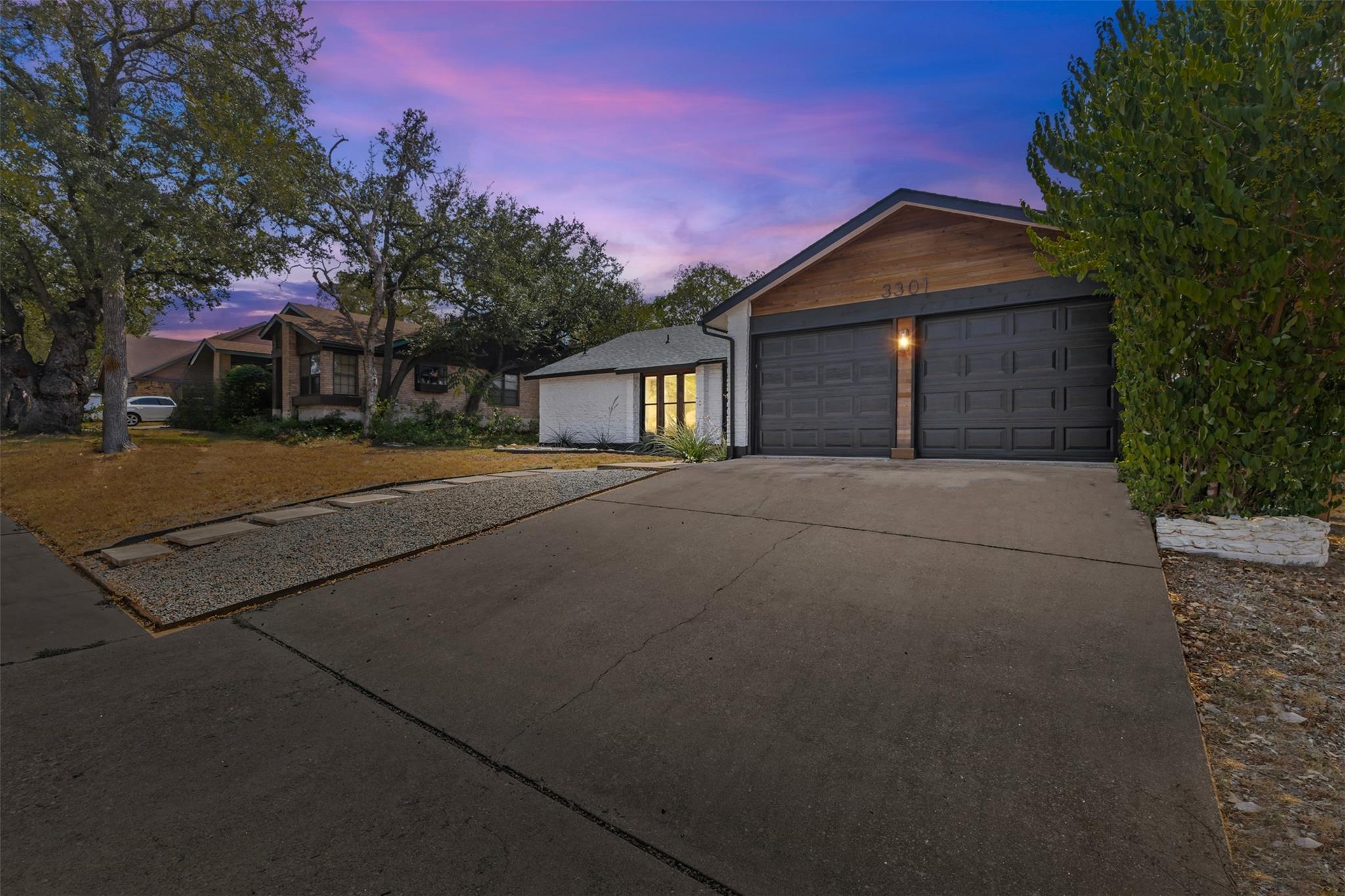 An inviting exterior features a wide concrete dri