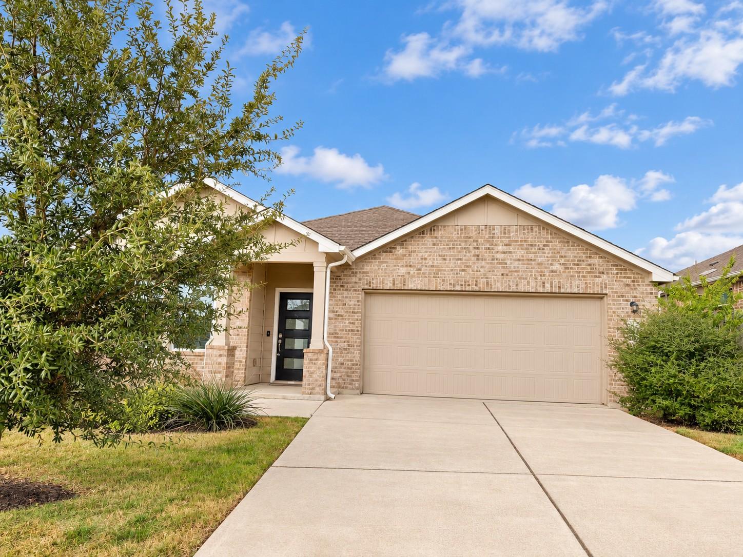 Classic brick exterior and a wide concrete drivew