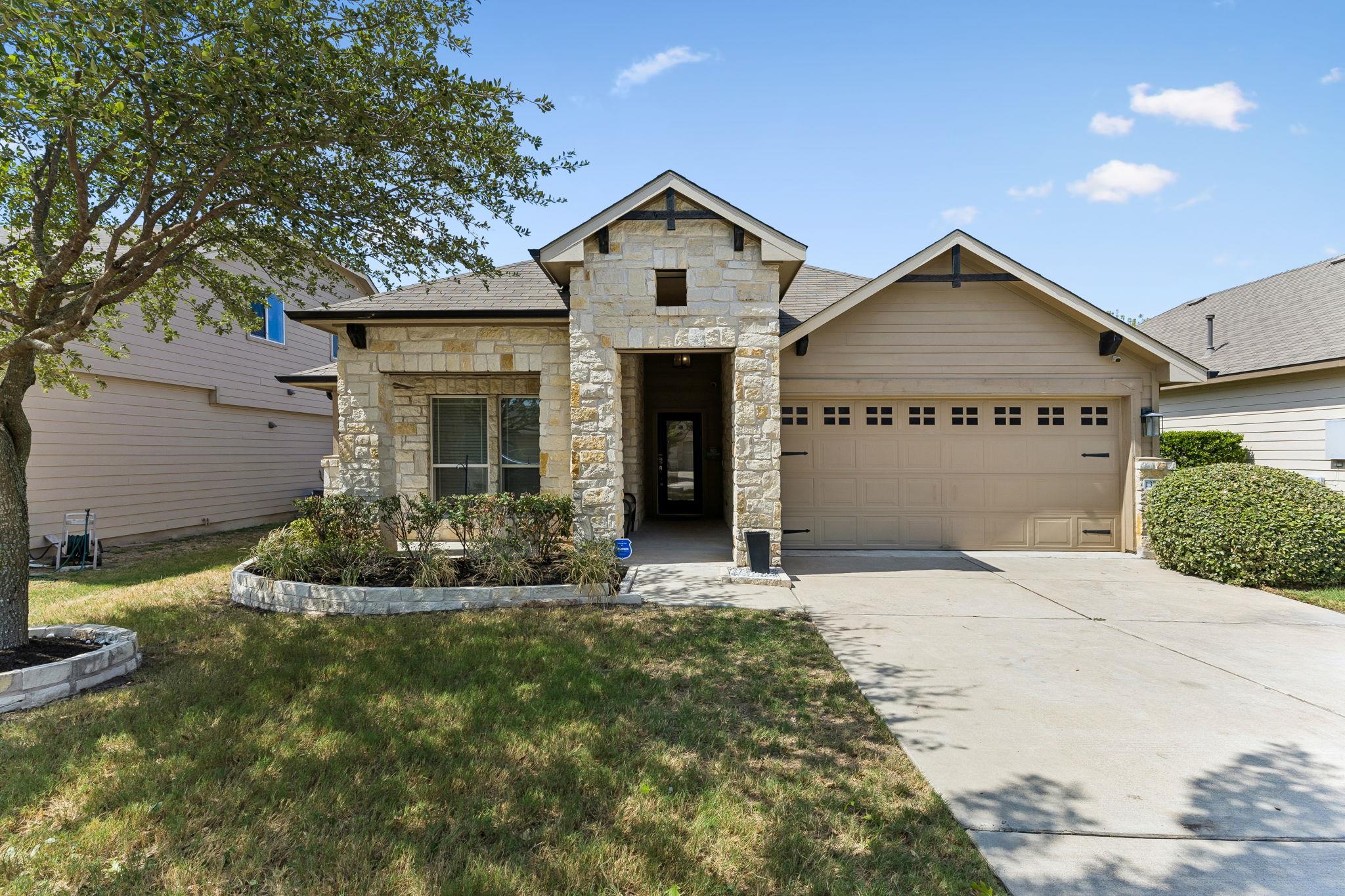Textured stone accents and a neat concrete drivew