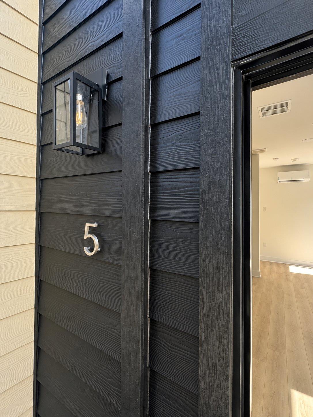 Modern vertical siding and a stylish light fixtur