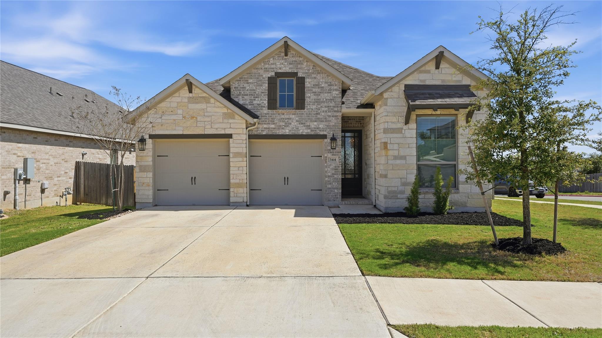 A classic stone facade and tidy concrete driveway