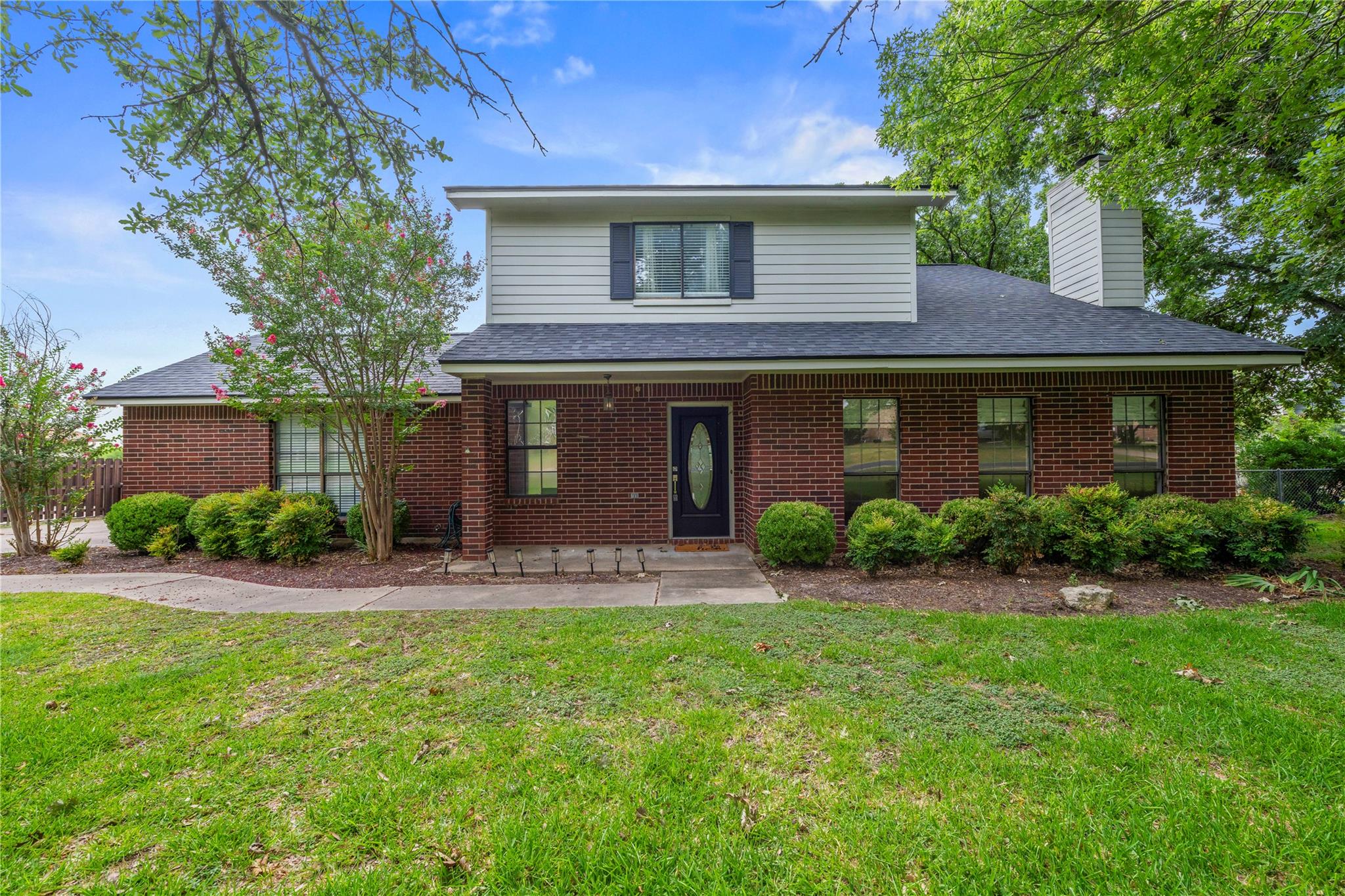 A classic brick and siding exterior stands surrou
