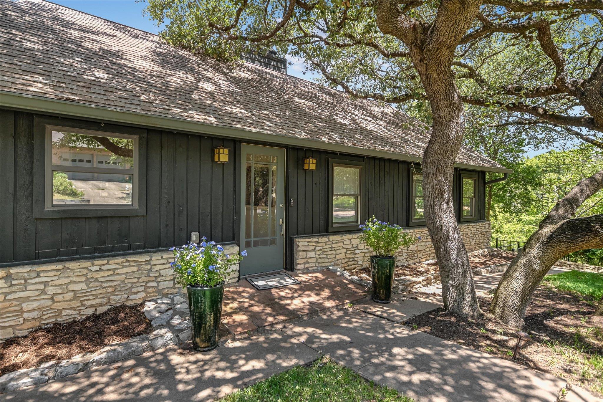 Mature shade trees frame a charming home exterior