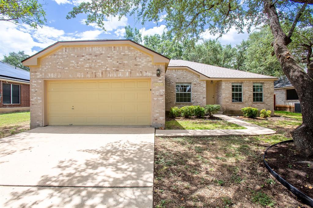 Mature trees shade a classic brick facade with an