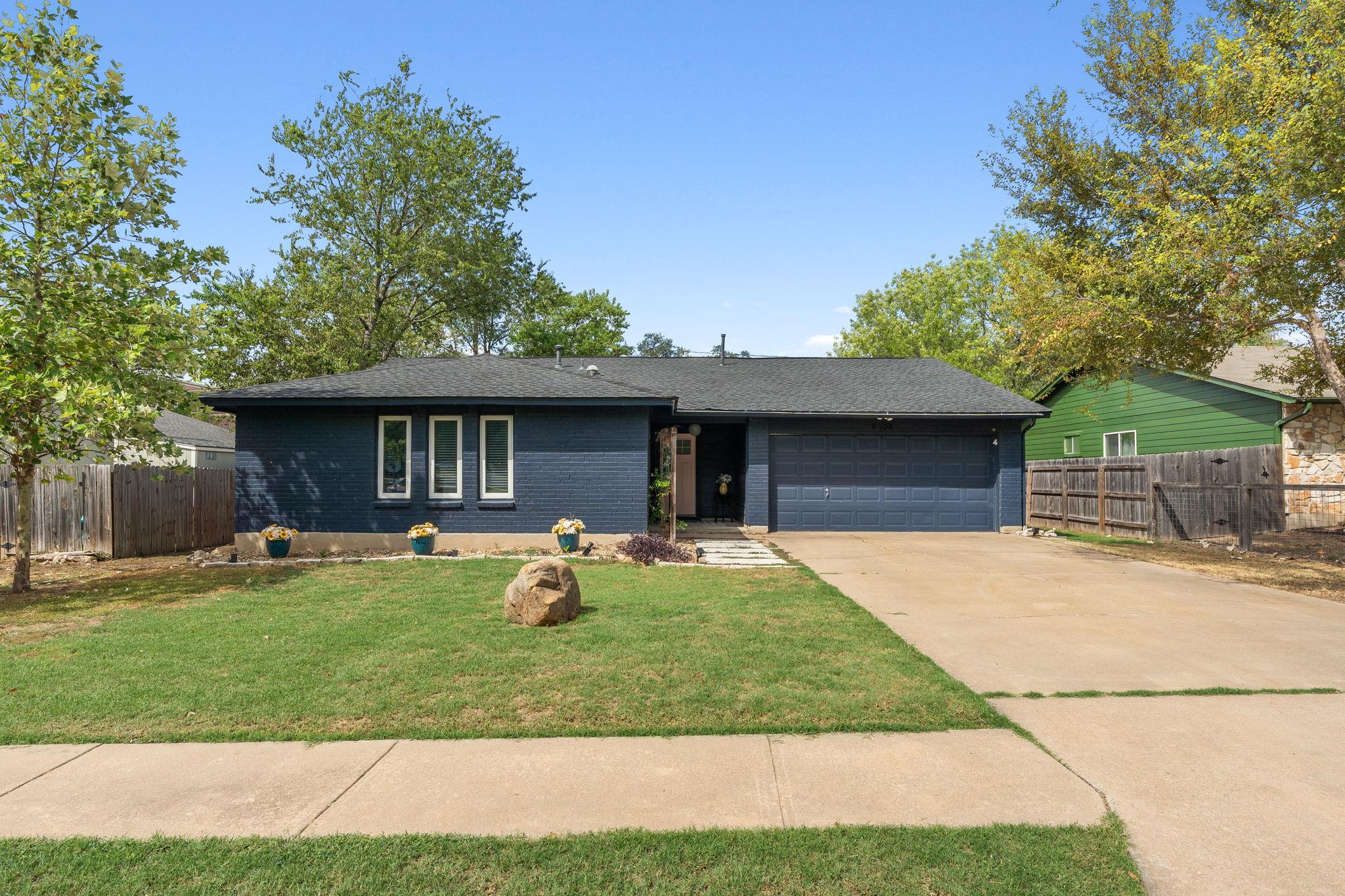 Mature trees frame a classic single-story exterio