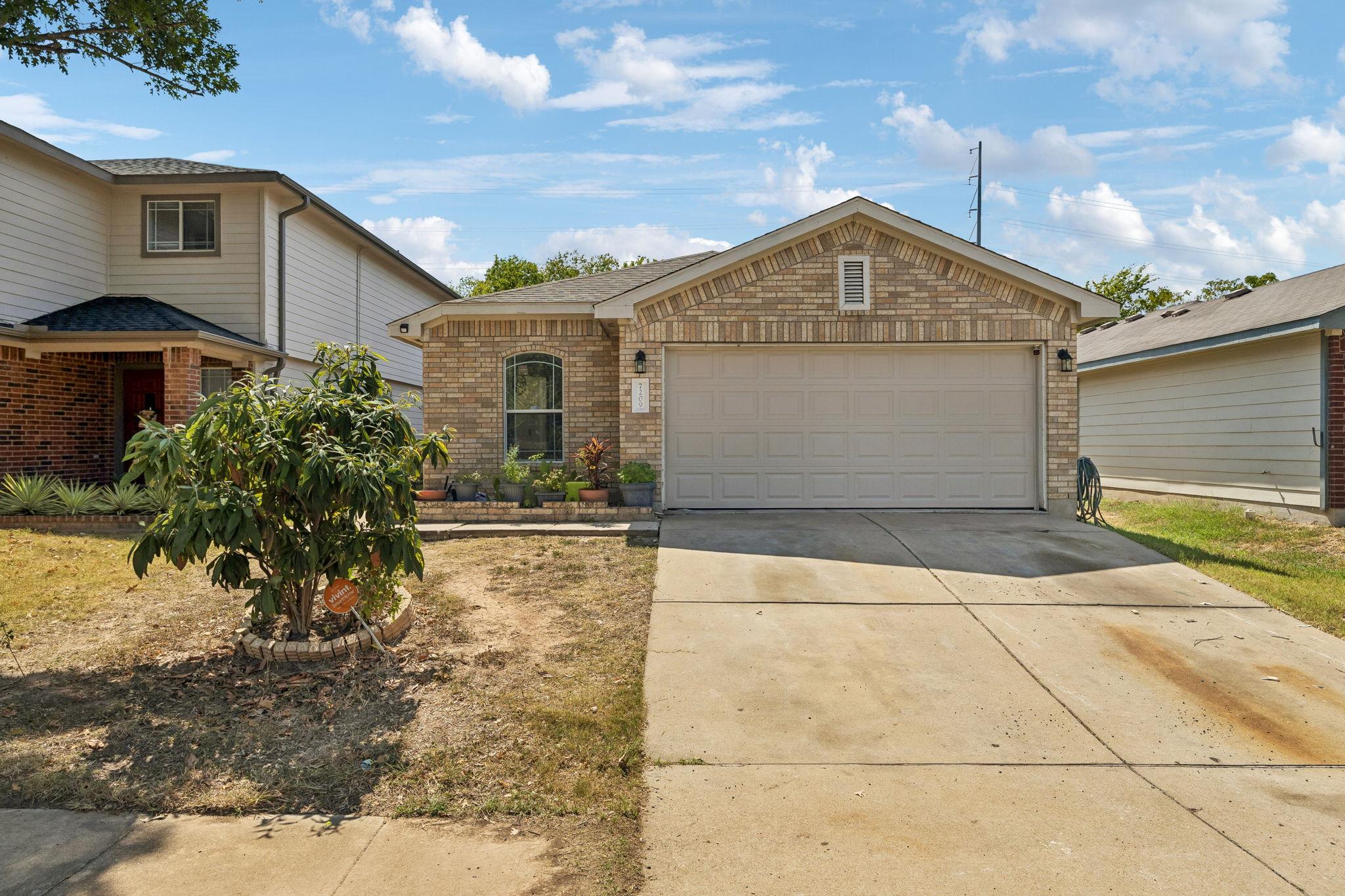 A classic brick exterior and concrete driveway de