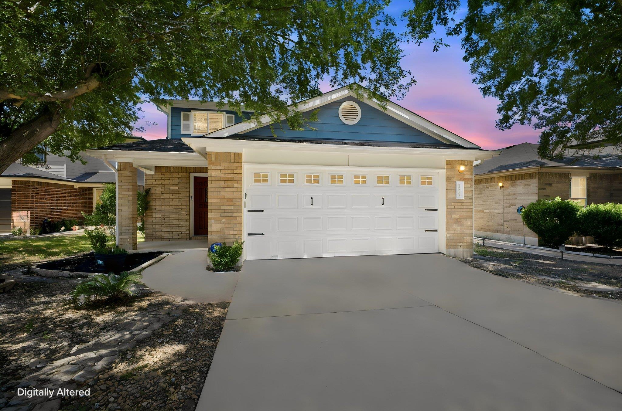 Warm brick accents and a spacious concrete drivew