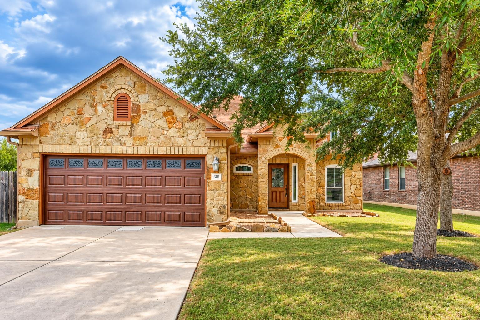 Natural stone masonry and a concrete driveway cre