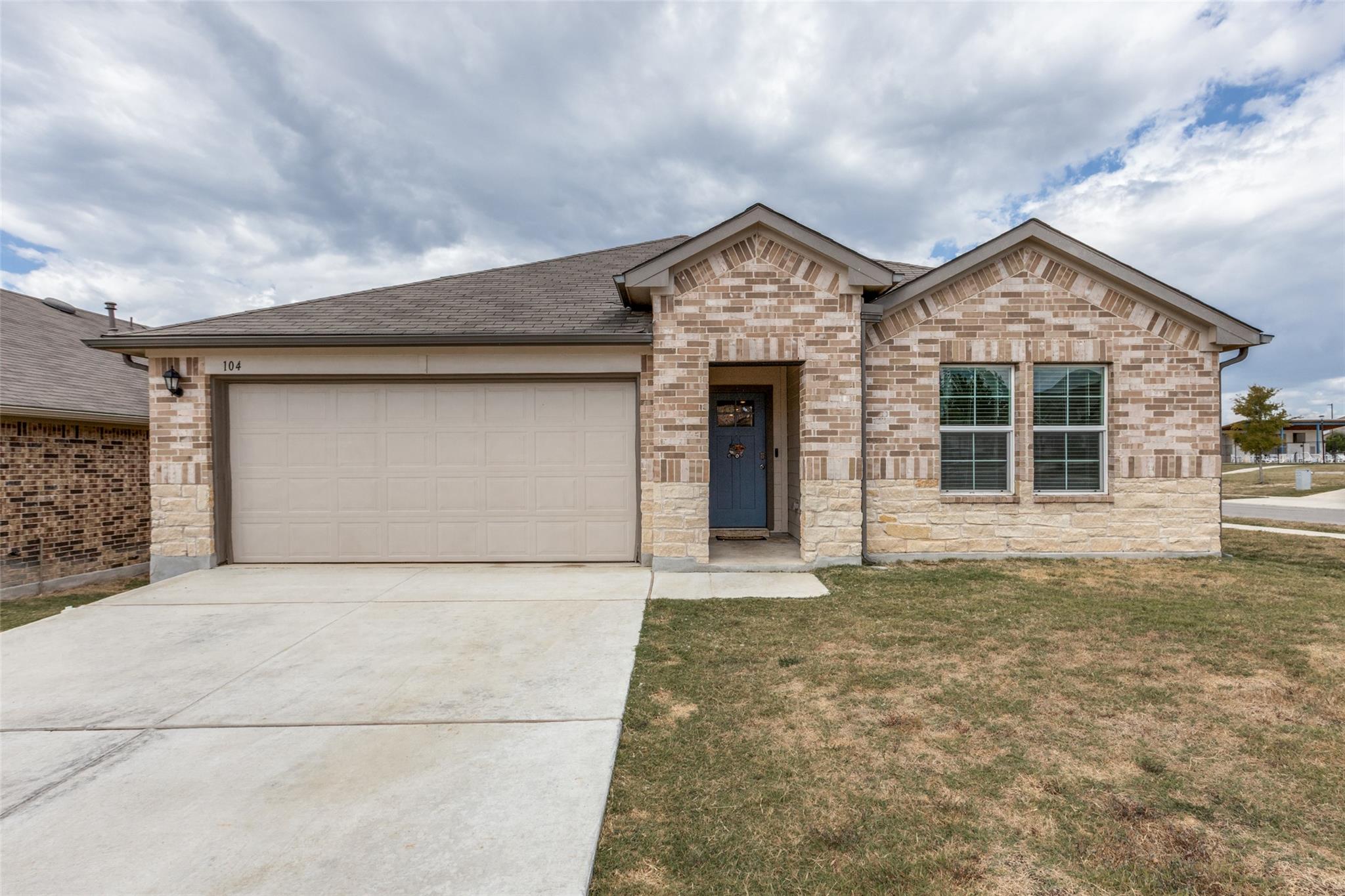An inviting stone and brick exterior features a s