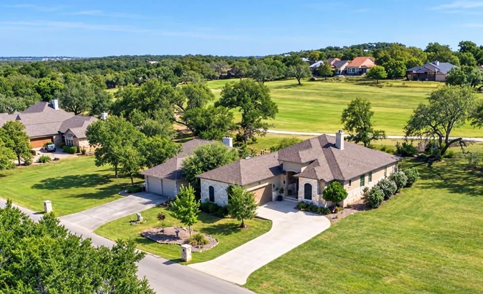 An expansive green lawn surrounds this stone-acce