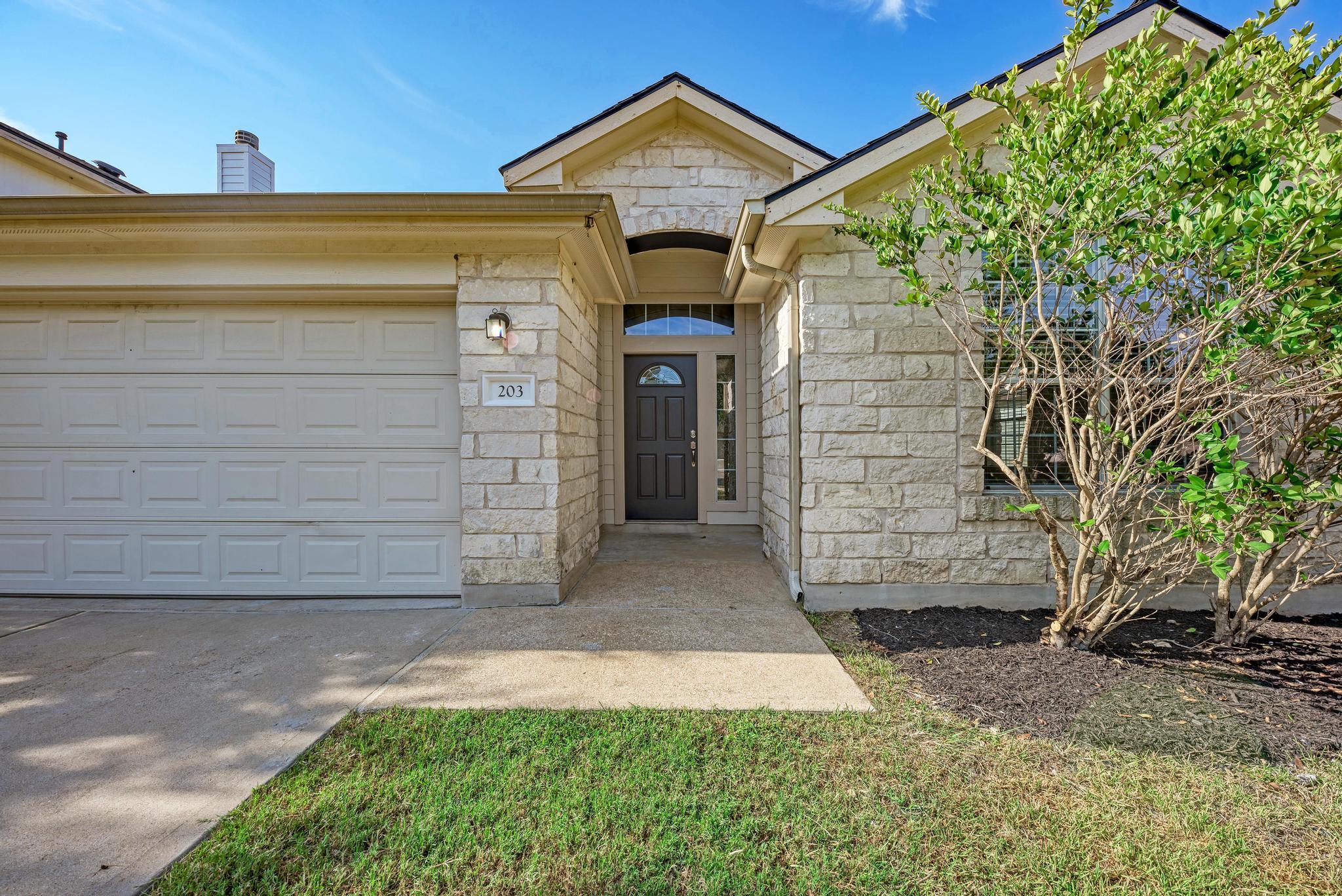 Natural stone exterior walls and a concrete drive