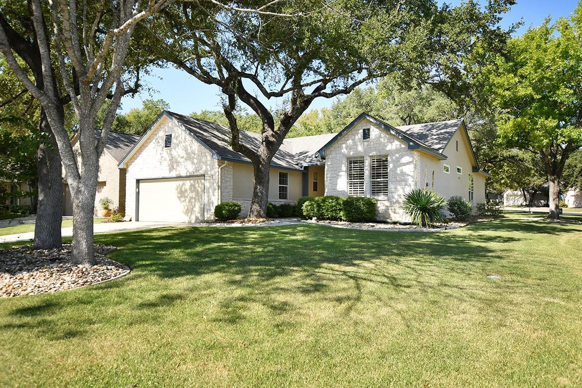 Mature shade trees frame a classic stone facade, 