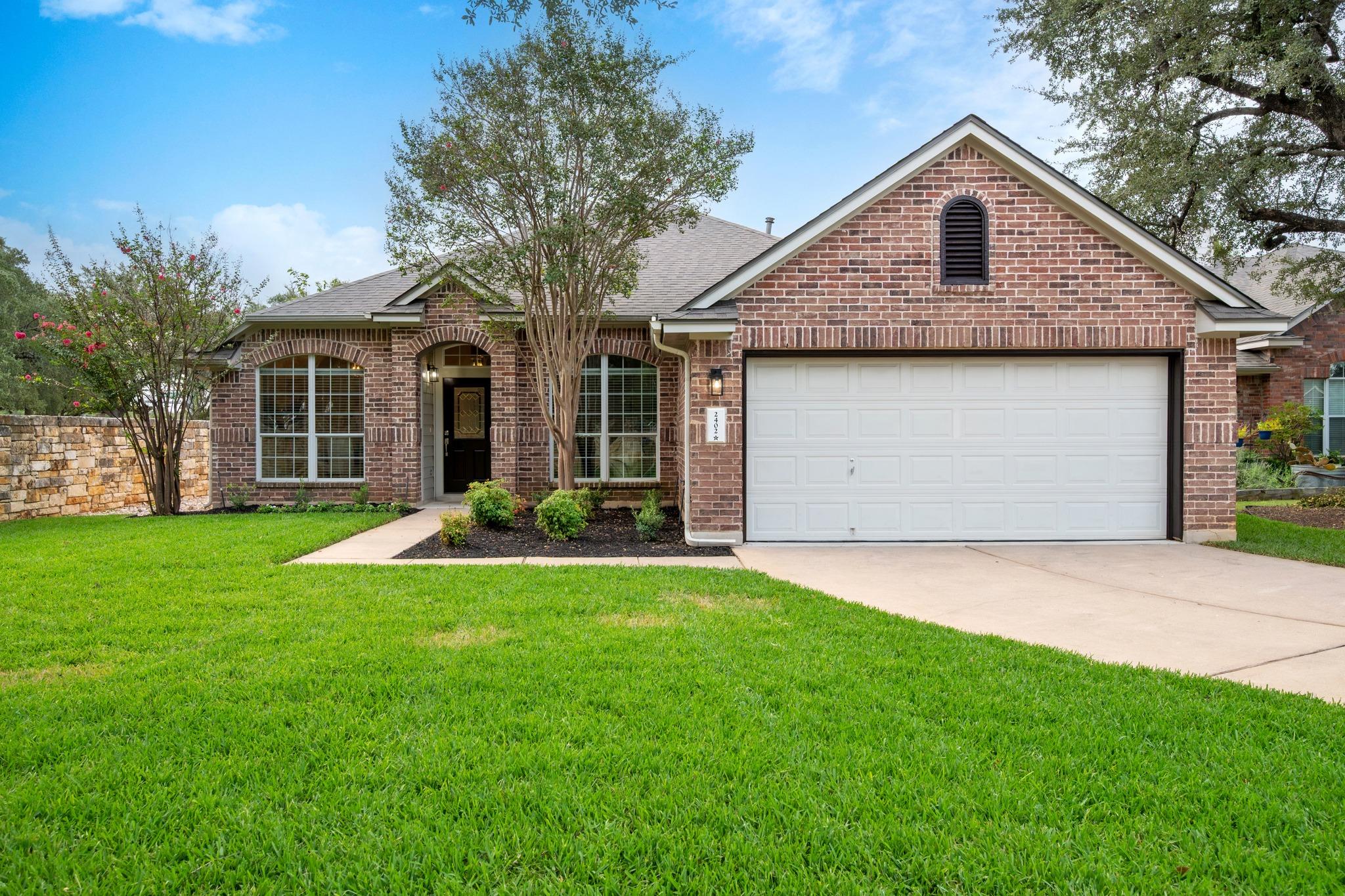 A classic brick exterior sits behind a manicured 