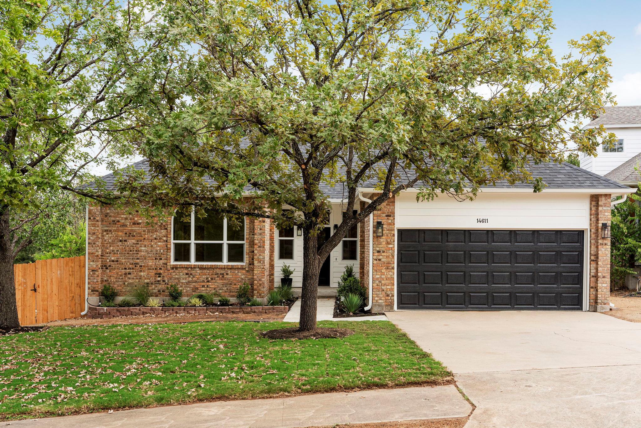 Mature trees shade a classic brick facade with an