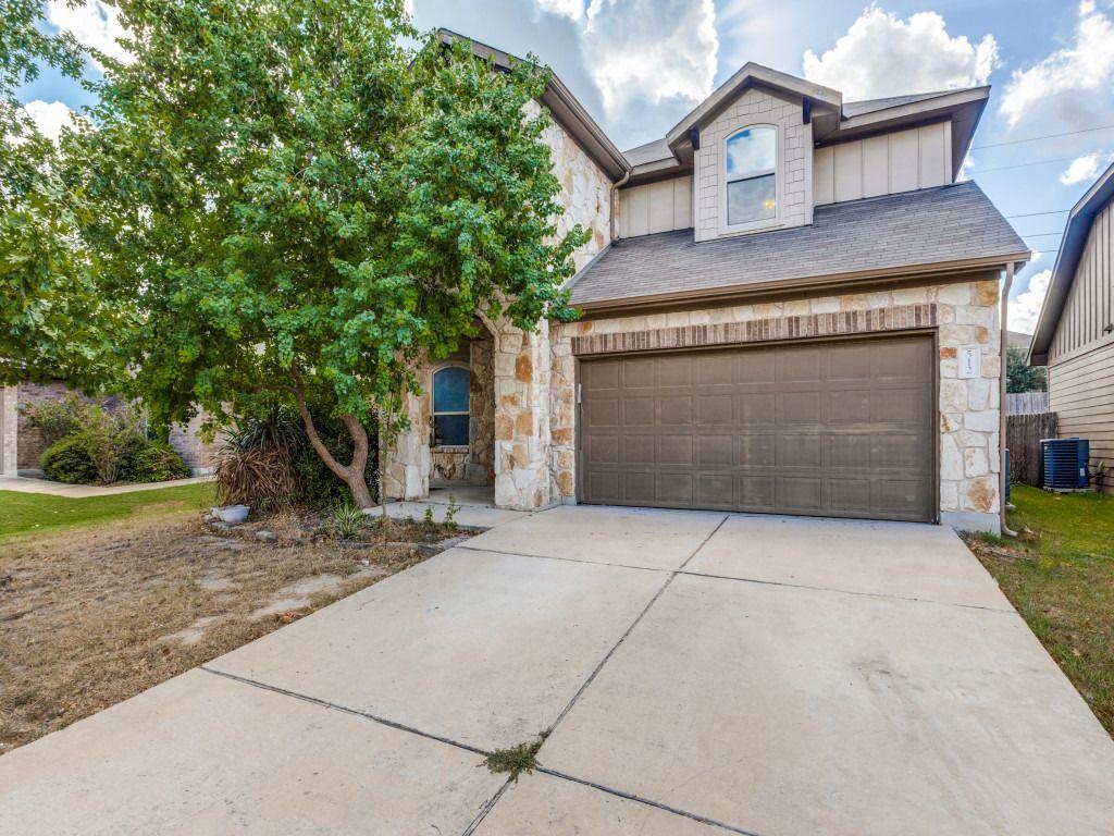 Natural stone accents and a spacious concrete dri