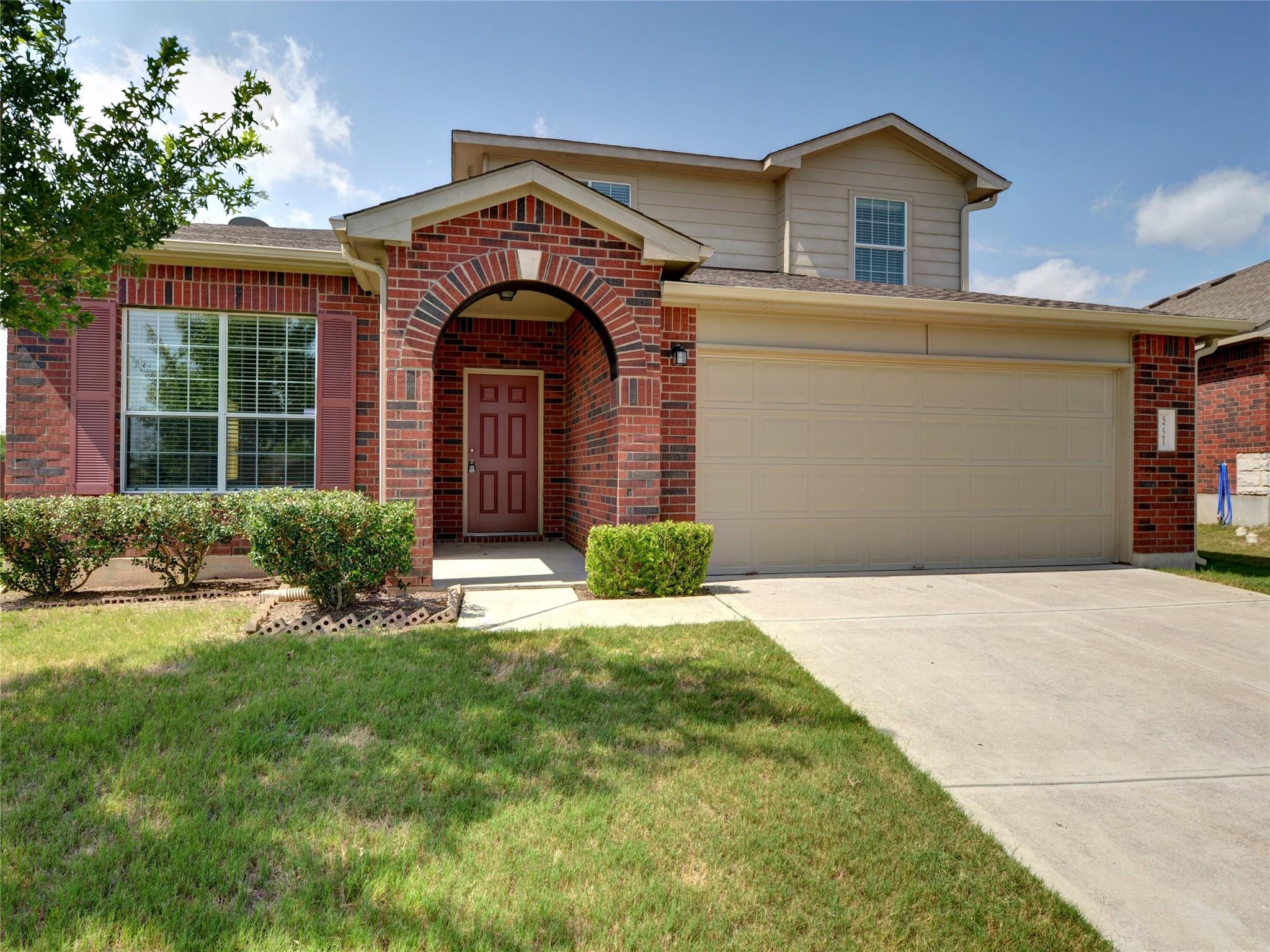 An arched brick entryway defines the classic exte