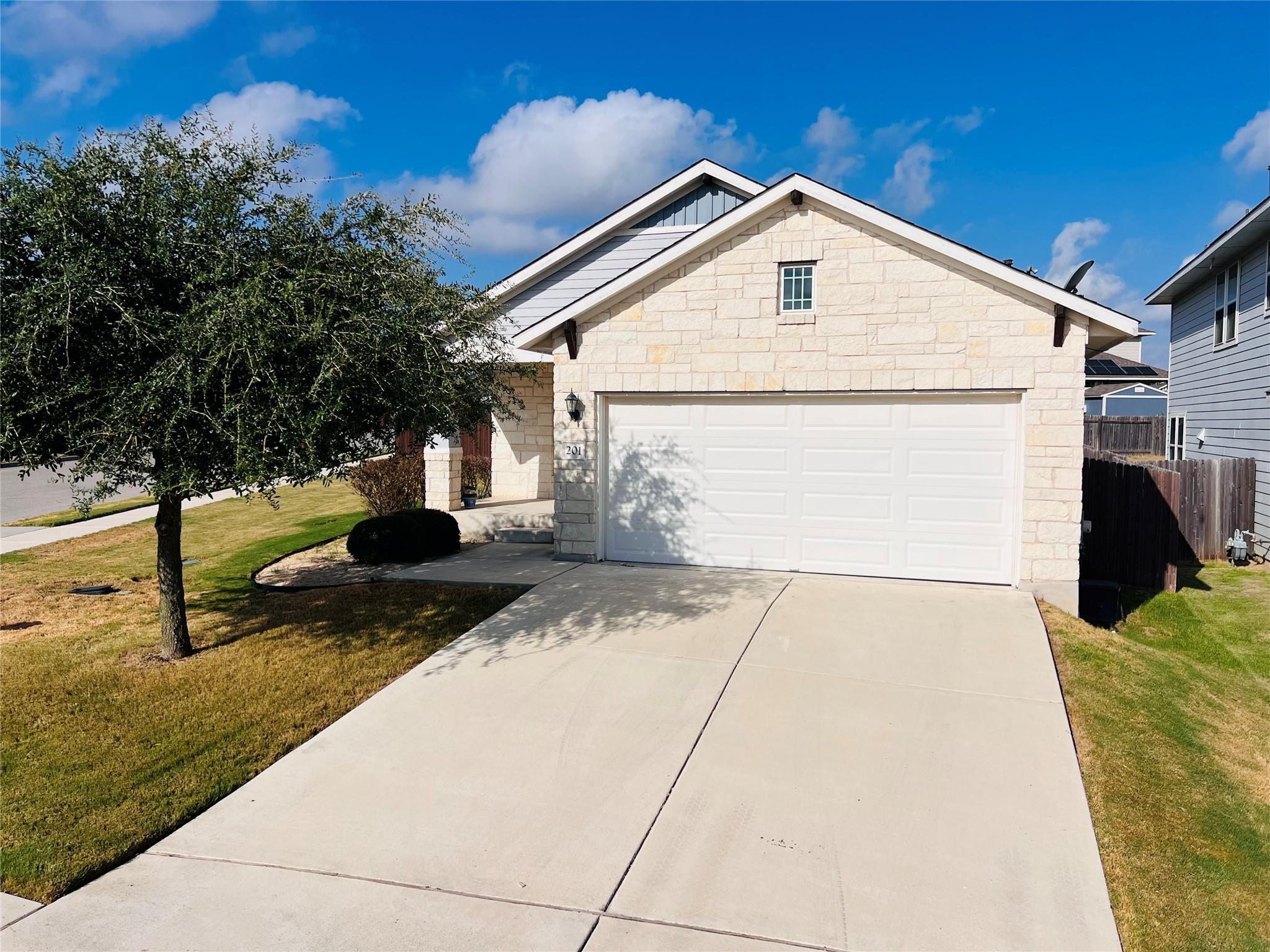 A classic stone facade and tidy concrete driveway