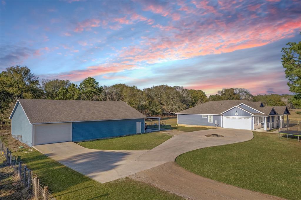 A spacious driveway connects the main residence a