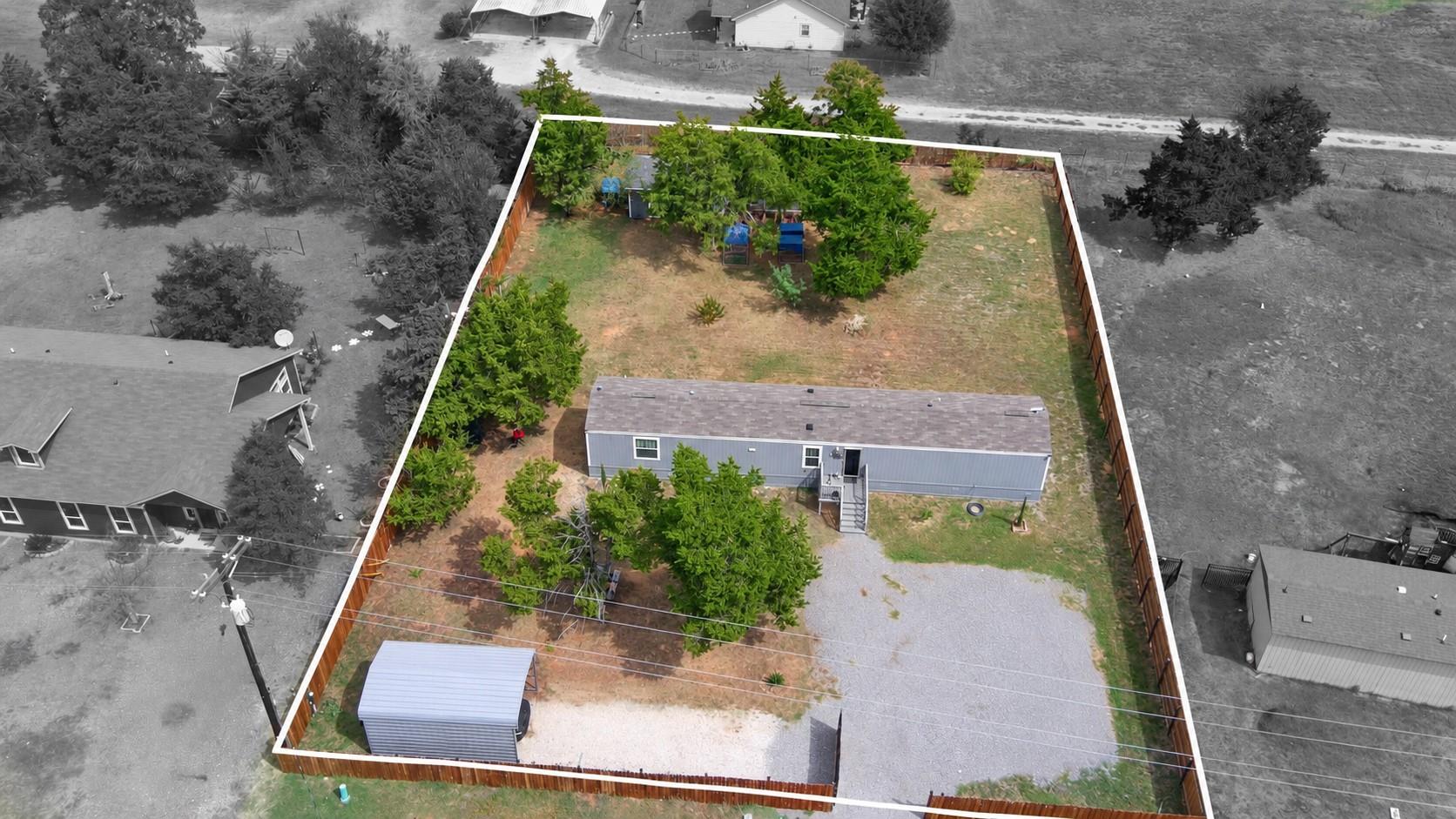An aerial perspective showcases a fully fenced ya