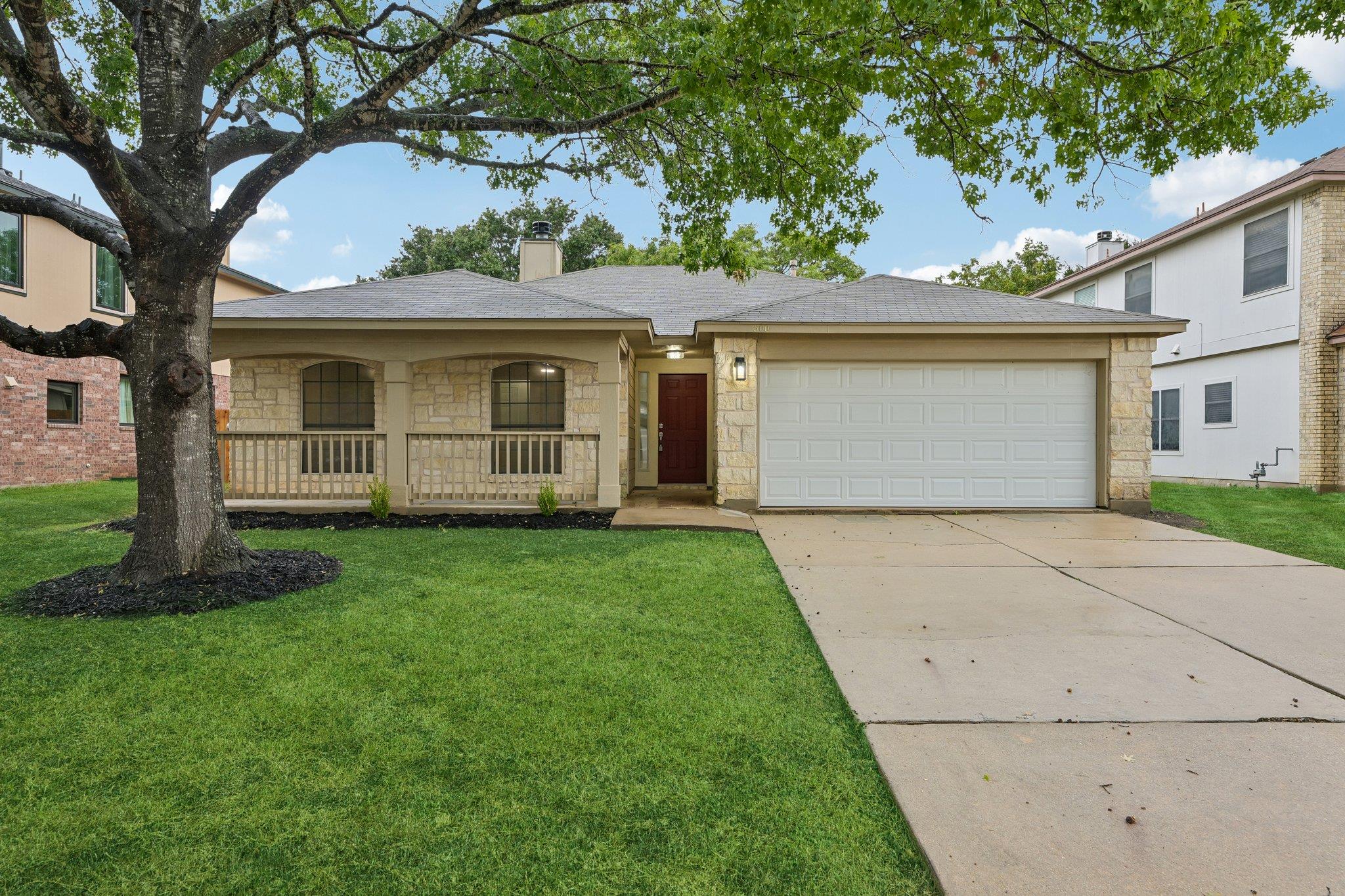 Limestone masonry accents and a broad driveway de