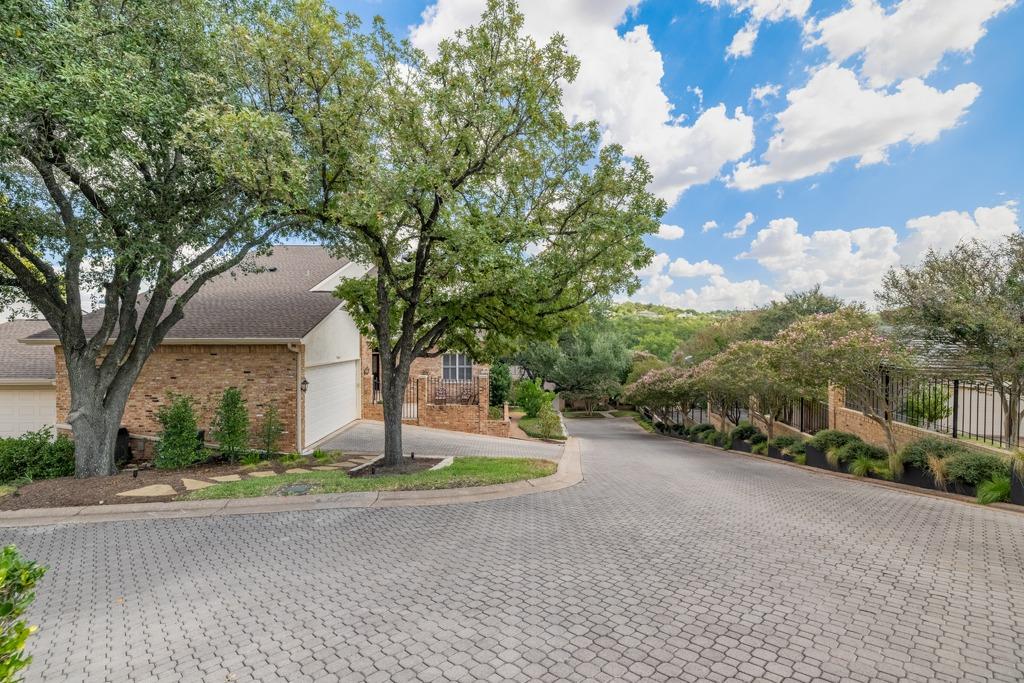 Mature trees and neat brick exteriors frame a qui
