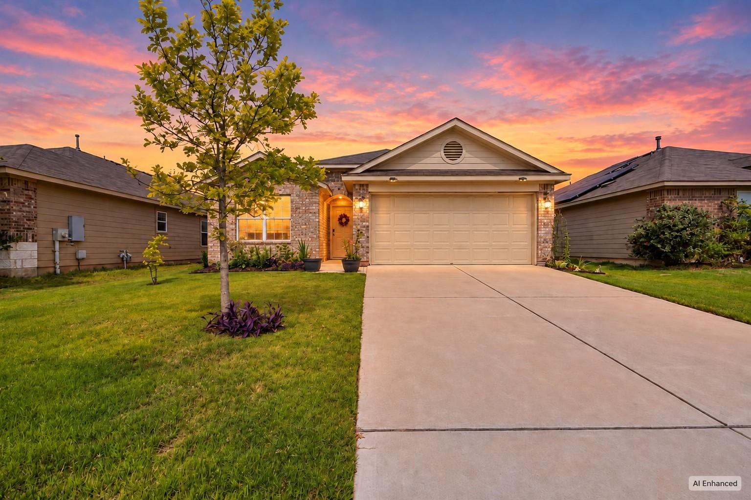 A concrete driveway leads to a classic brick faca